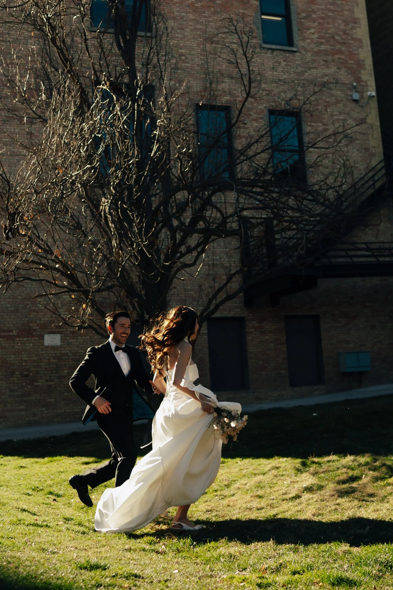 Bride and Groom in classic elegant wedding attire surrounded by beautiful stonework architecture during a downtown formals photoshoot - Poise and Ivy Imagery