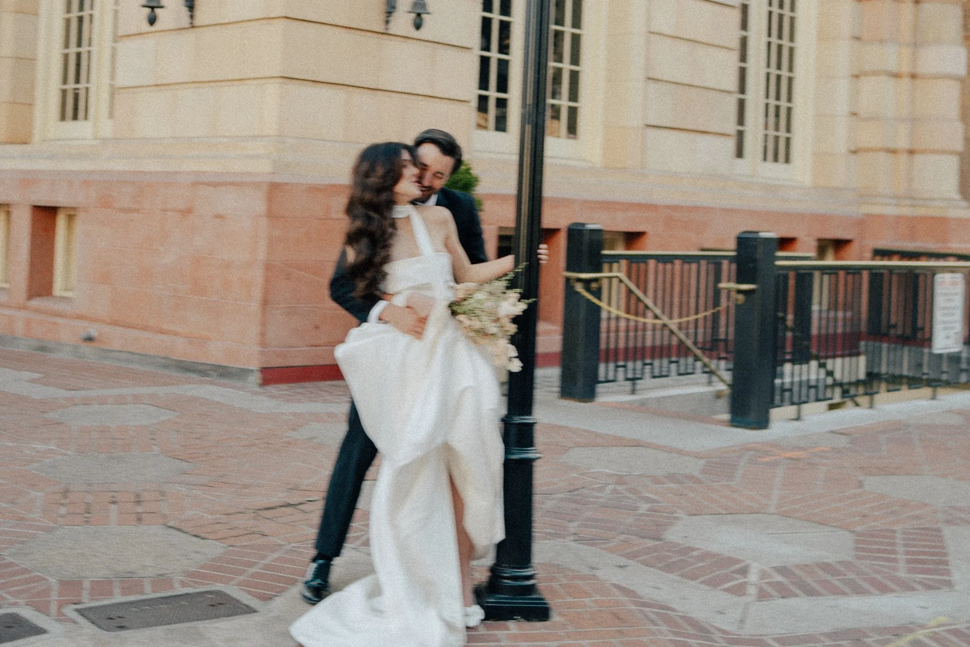 Bride and Groom in classic elegant wedding attire surrounded by beautiful stonework architecture during a downtown formals photoshoot - Poise and Ivy Imagery