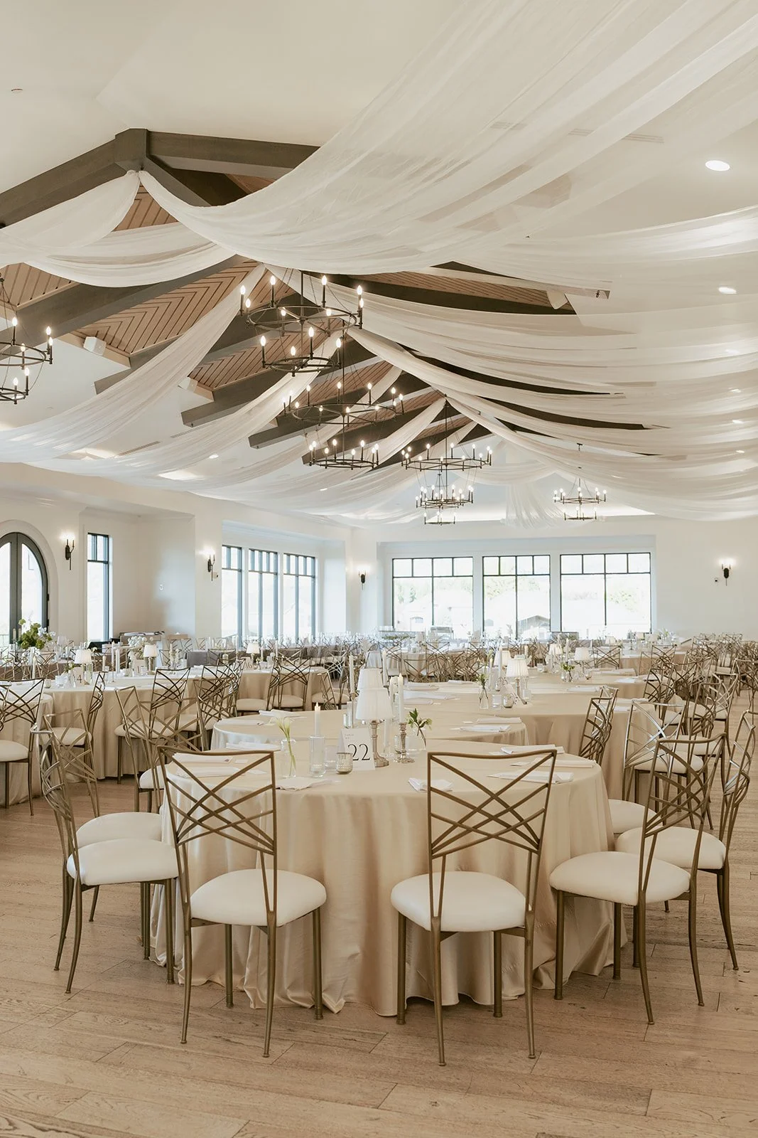wedding reception details featuring white pillar candles in glass vases against a soft grey tablecloth - Photography by Poise and Ivy Imagery, Wedding Design by Britt Warnick Designs