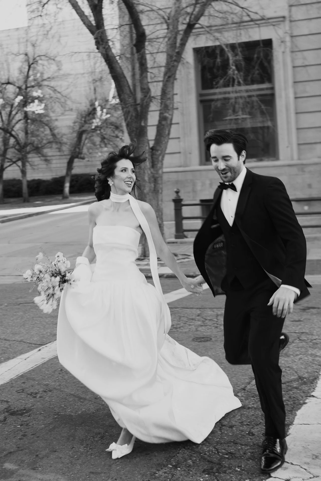 Bride and Groom in classic elegant wedding attire surrounded by beautiful stonework architecture during a downtown formals photoshoot - Poise and Ivy Imagery