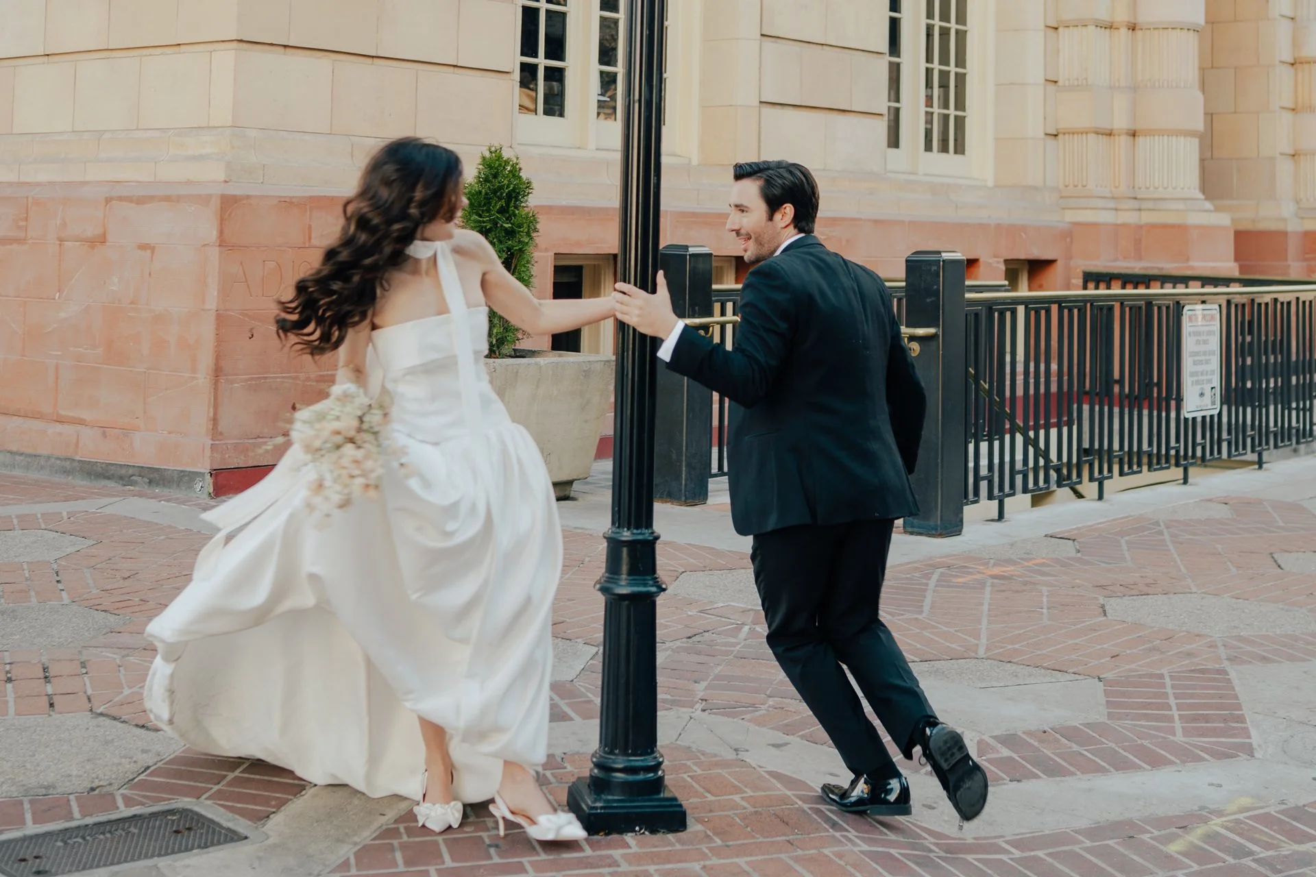 Bride and Groom in classic elegant wedding attire surrounded by beautiful stonework architecture during a downtown formals photoshoot - Poise and Ivy Imagery