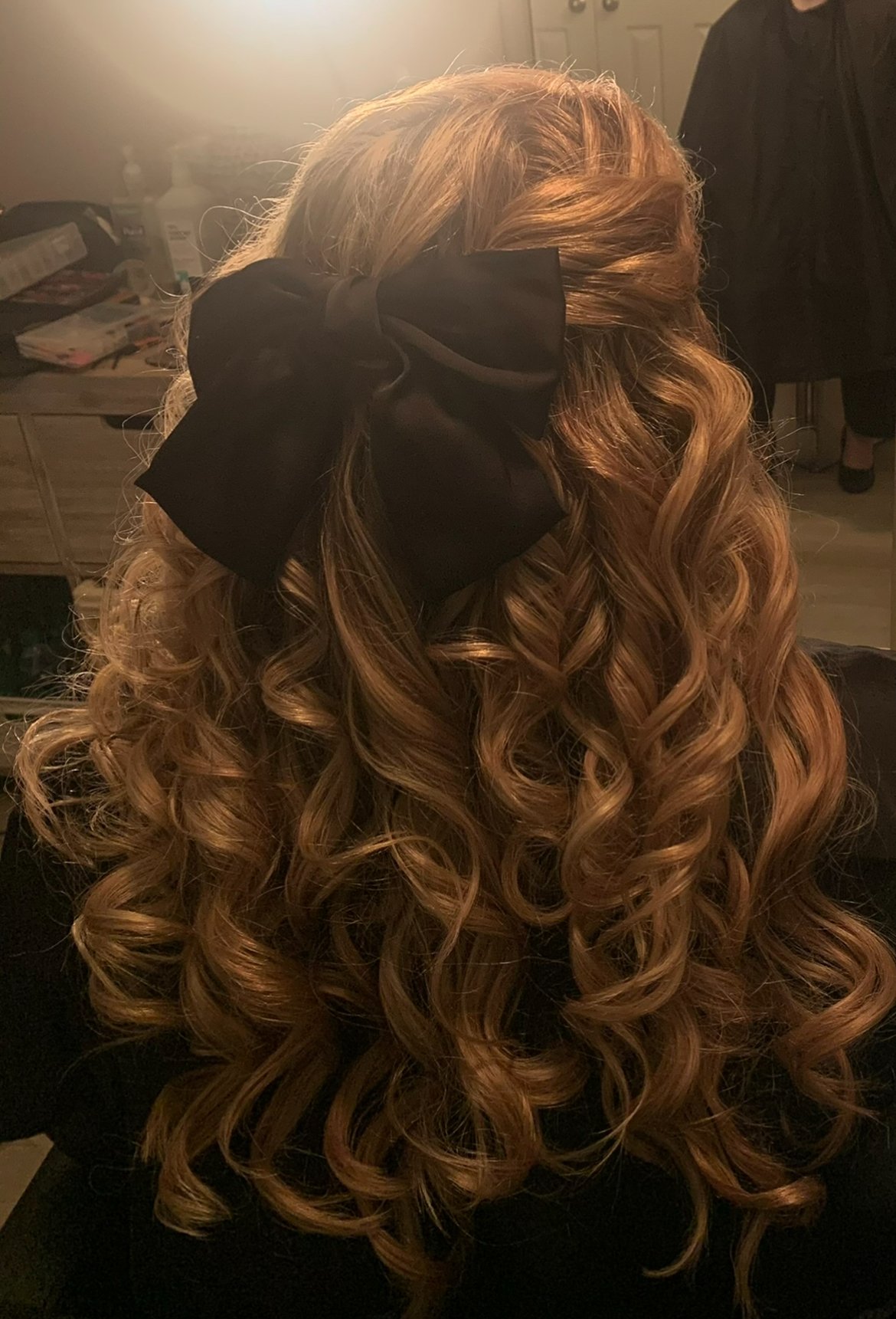 red hair curled and styled into a poof with a big black bow