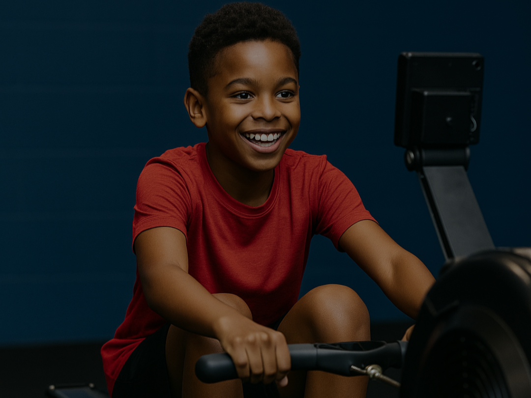 Young boy training on a rowing machine during CrossFit Kids class at CrossFit 1864 East London near Canary Wharf.