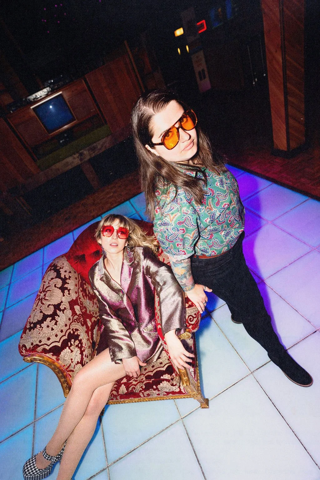 Daddy the Band indie glitter rock duo press photo in retro neon lounge setting with colorful vintage styling, San Diego band