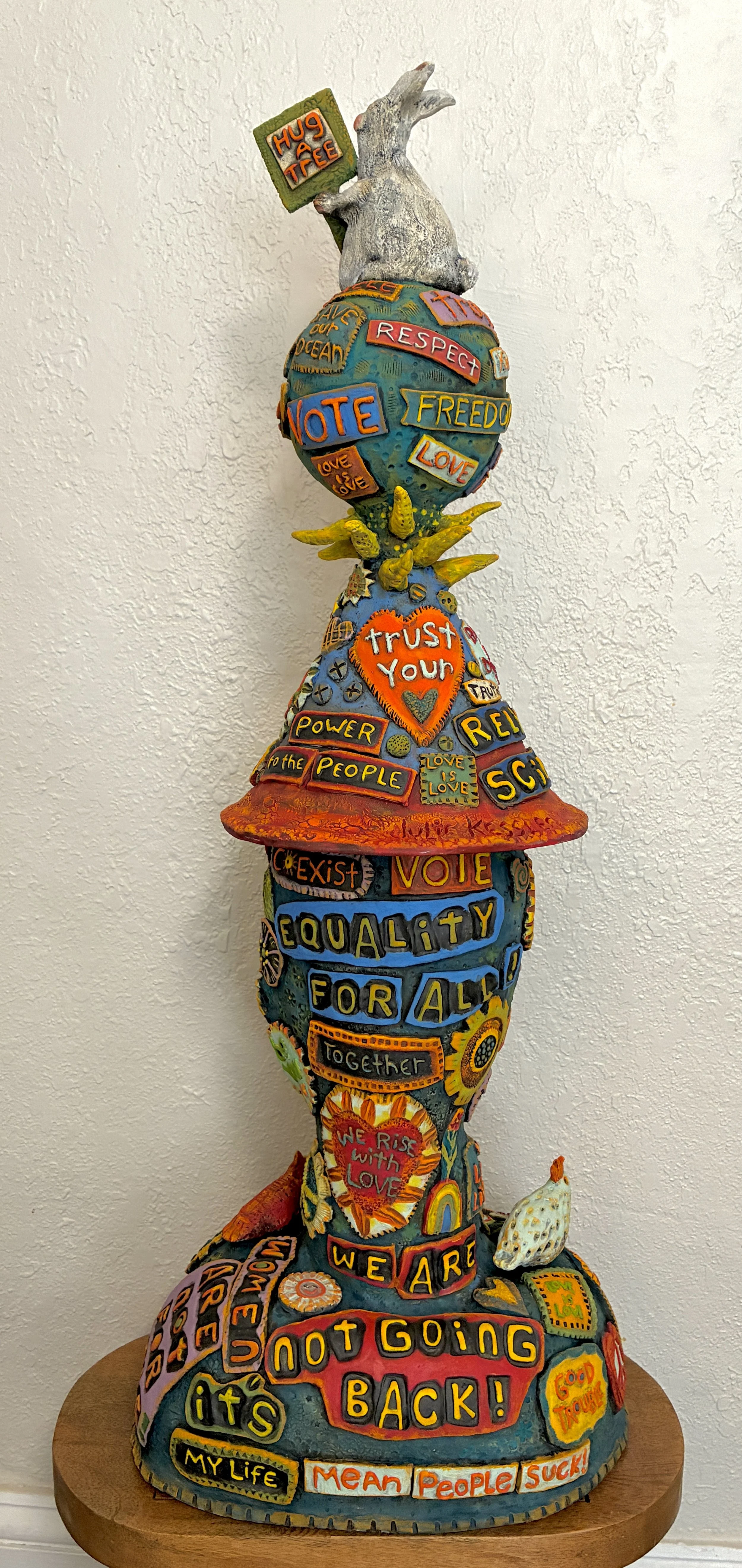 Julie Kessler; Power to the People; 37" X13"X13"; Ceramic; My sculpture is a call to action wrapped in color, texture and with positive messaging supporting Love & Kindness, Women’s Rights, Climate Concerns, Equal Rights and more.; $3000