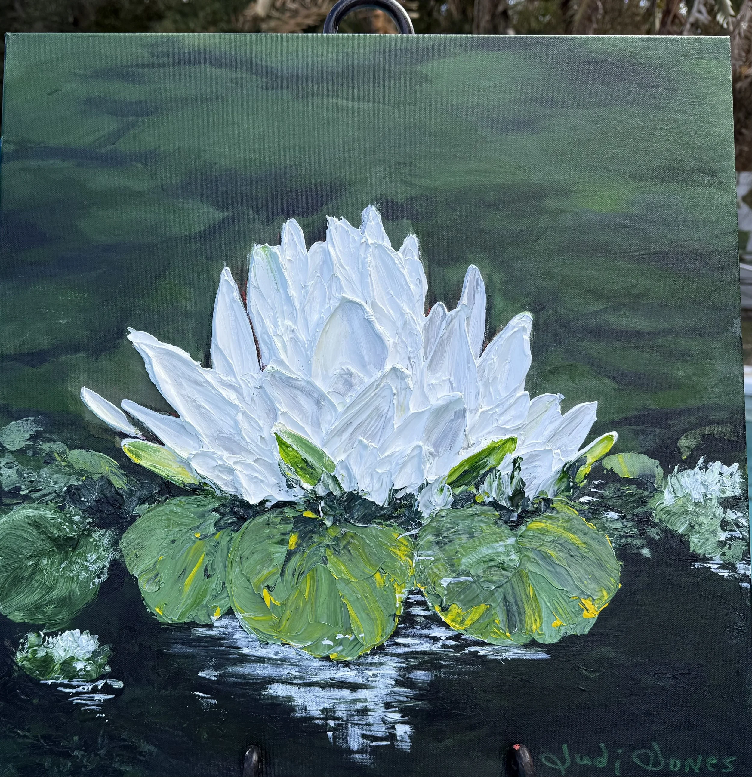 Judi Jones; Serenity; Acrylic; 20”x20”; The Lotus blossom in full bloom floating signifies peace.  This painting represents the calm we all seek and gently reflects on the water and our mood.; $550