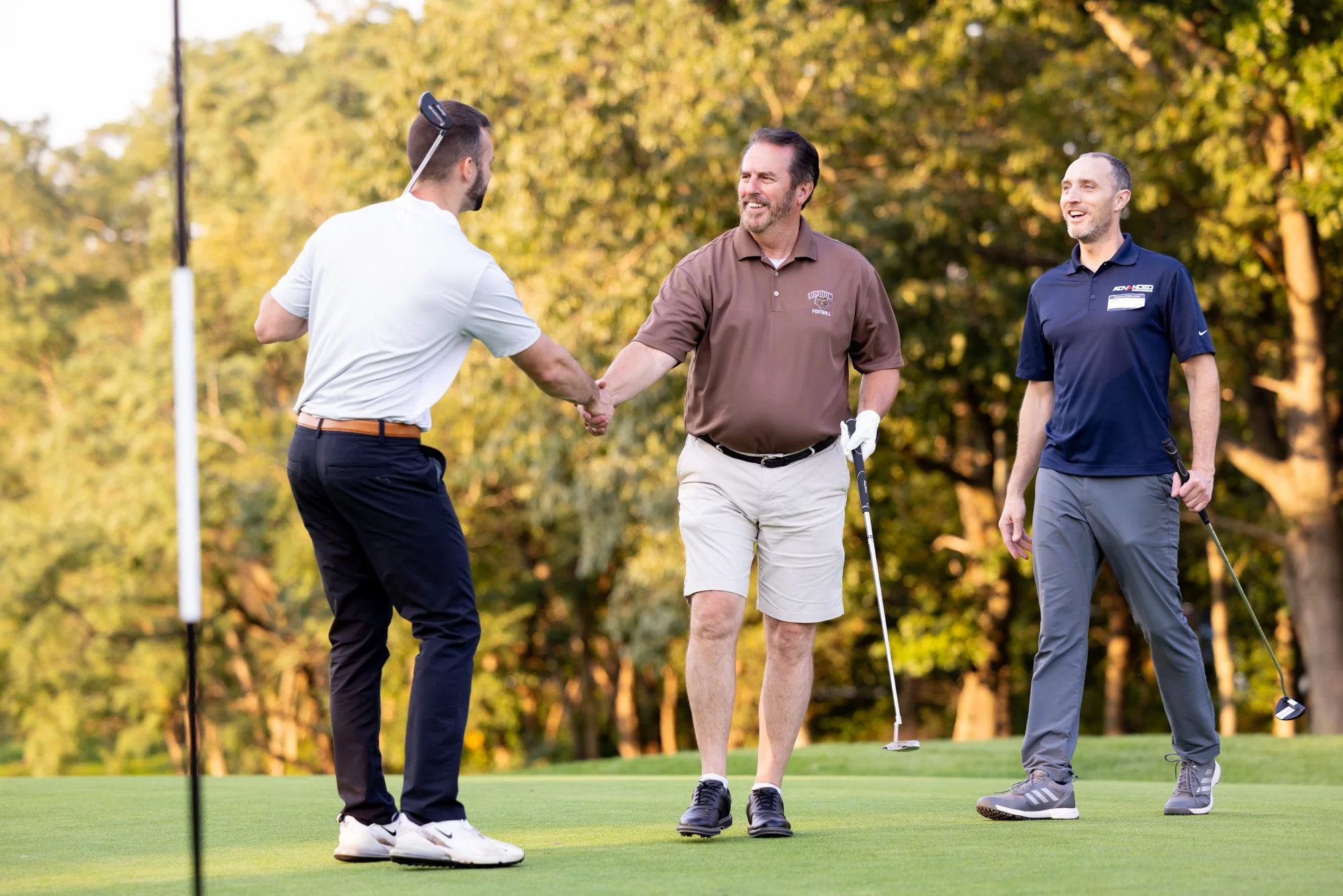 Golfers shaking hands on the green