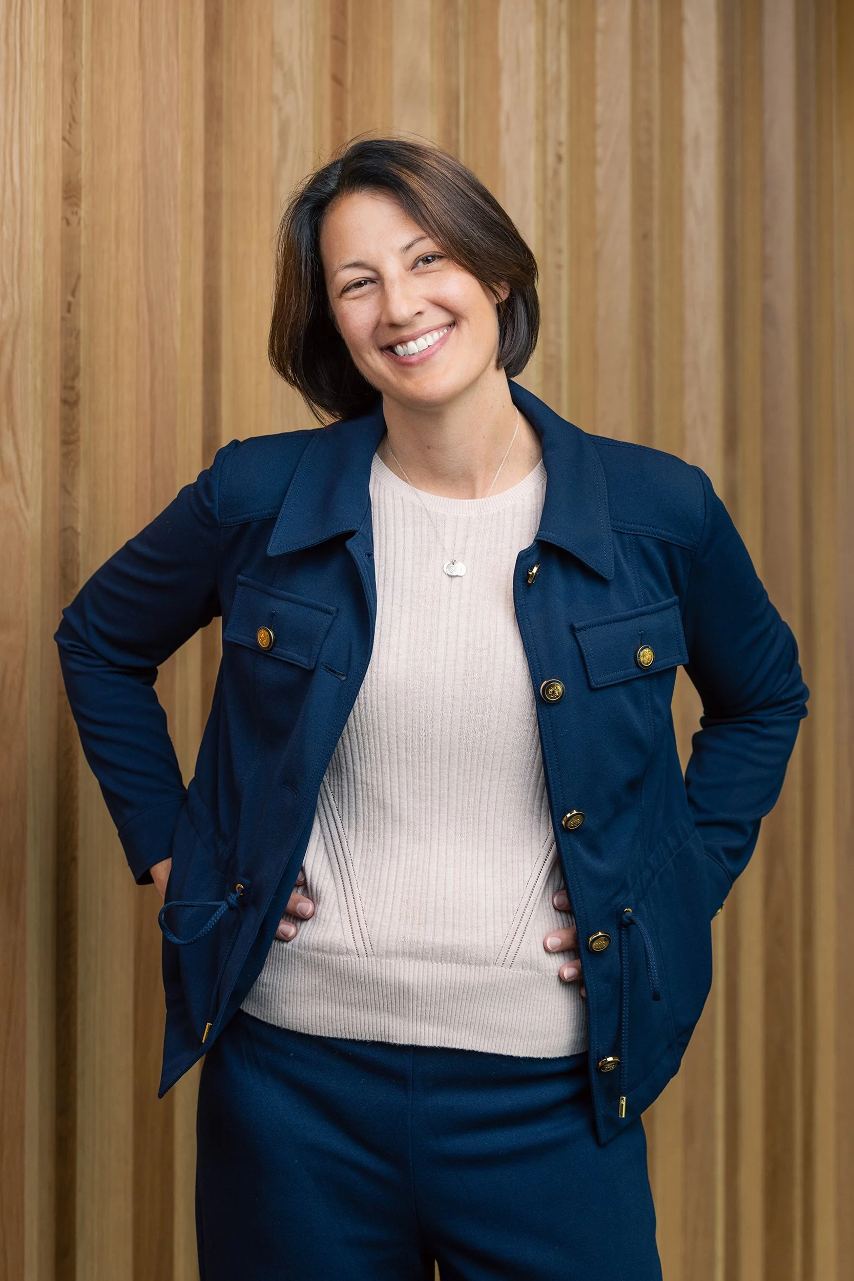 Professional Portrait of woman standing against wood wall