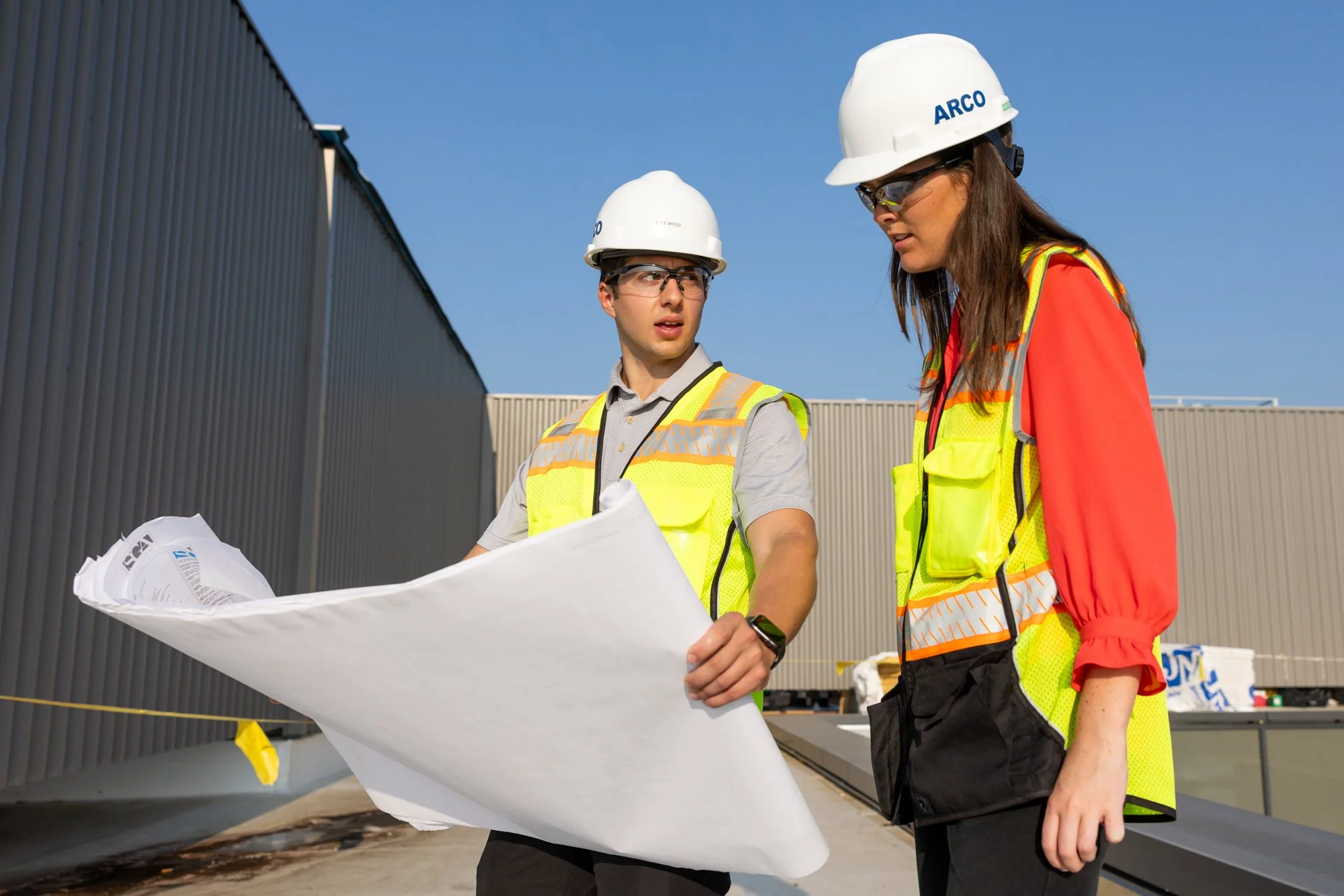 Two people looking at drafting papers
