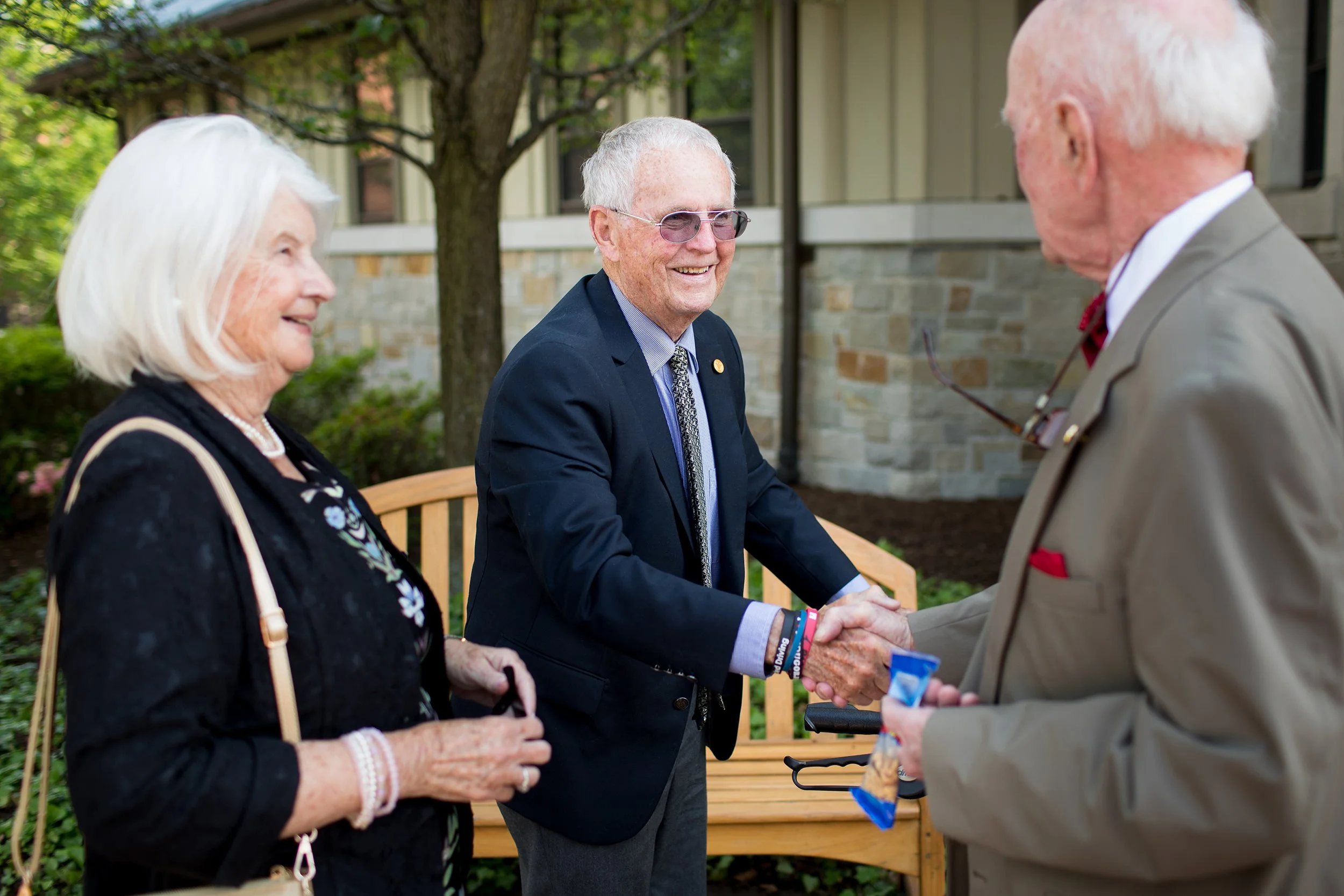 Older man shaking hands during class reunion
