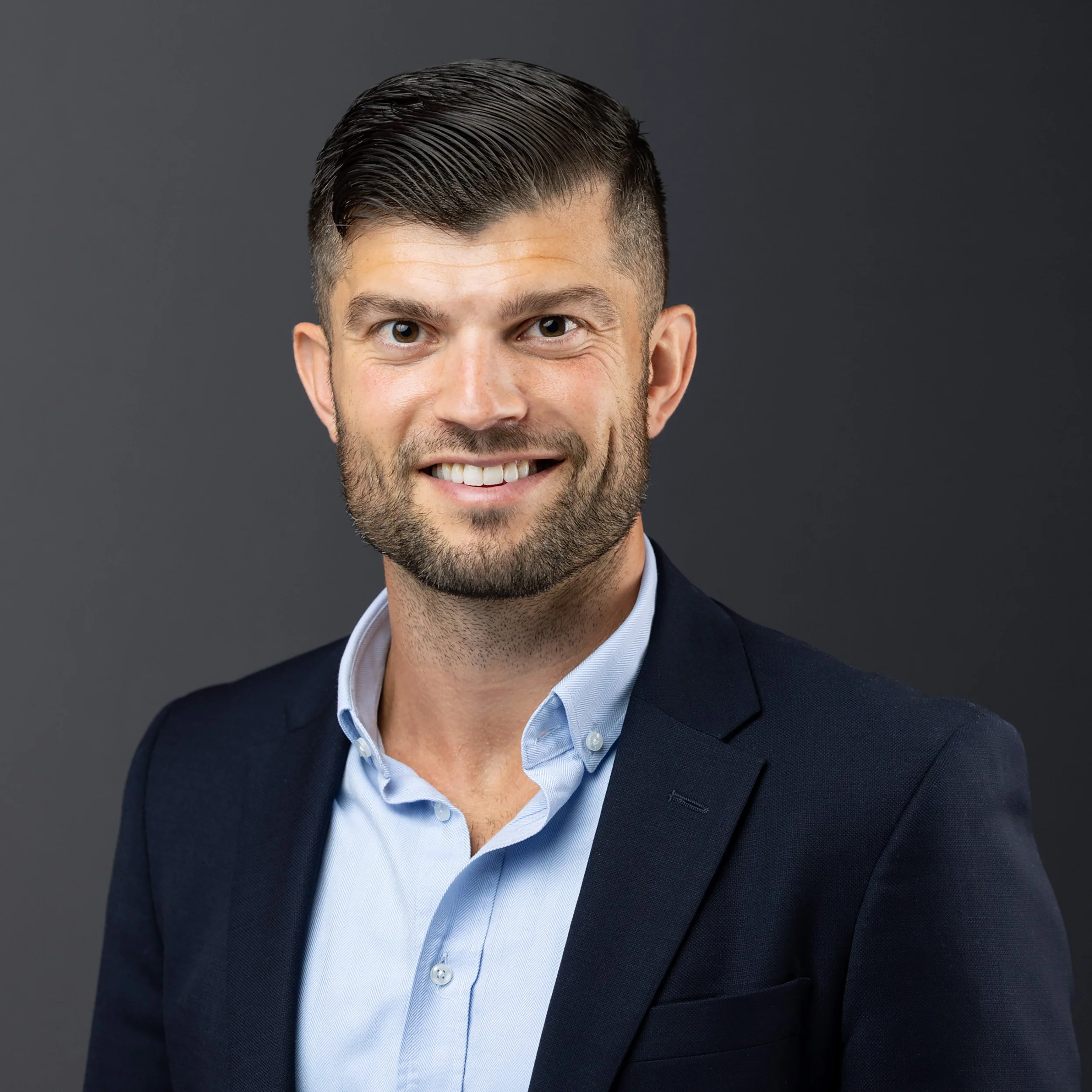 Headshot of man against a dark background