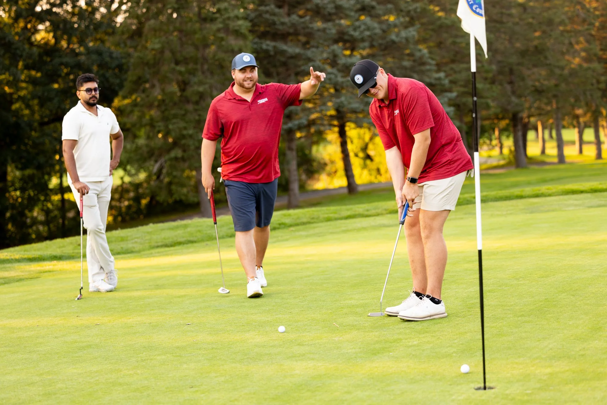 Three people on golf green at flag