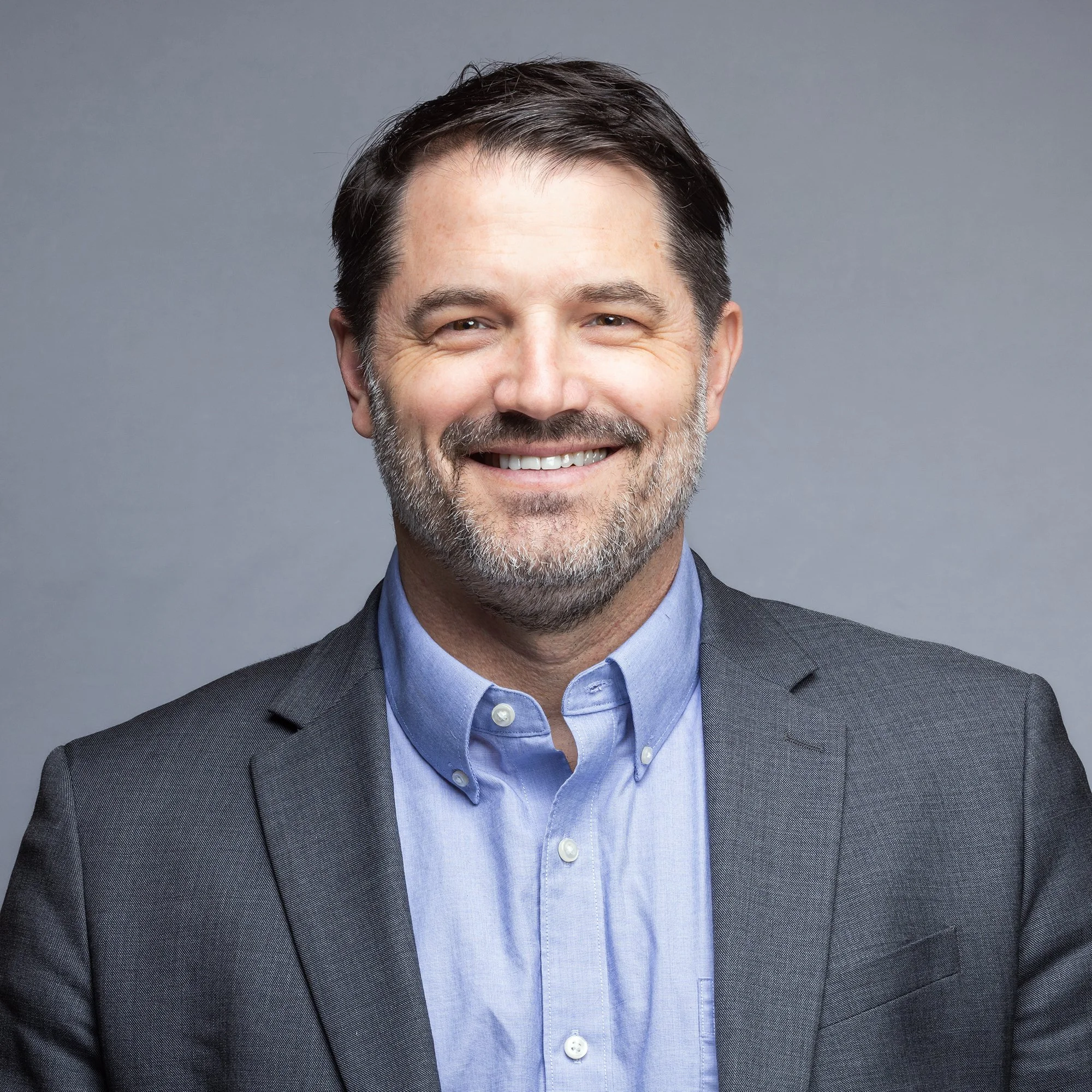 Corporate headshot of man against gray background