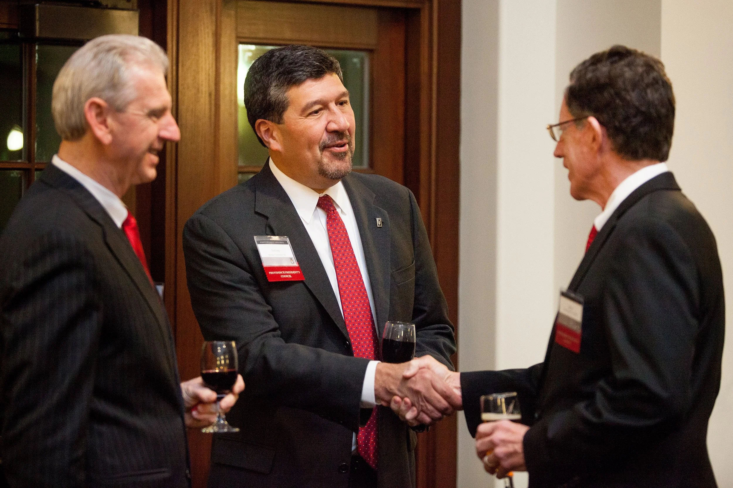 Two men shake hands during cocktail event