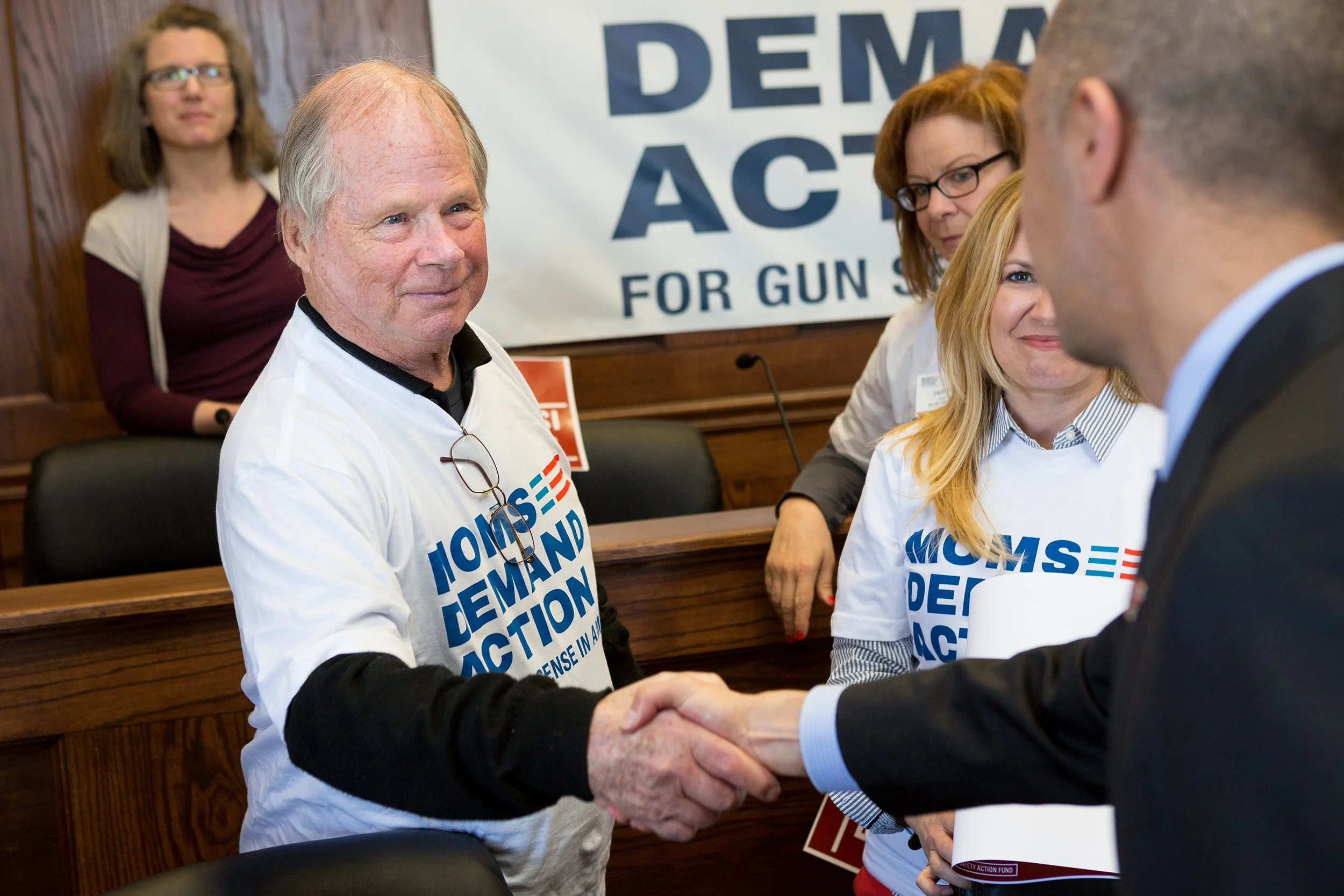 Man reaching out and shaking another hand at event