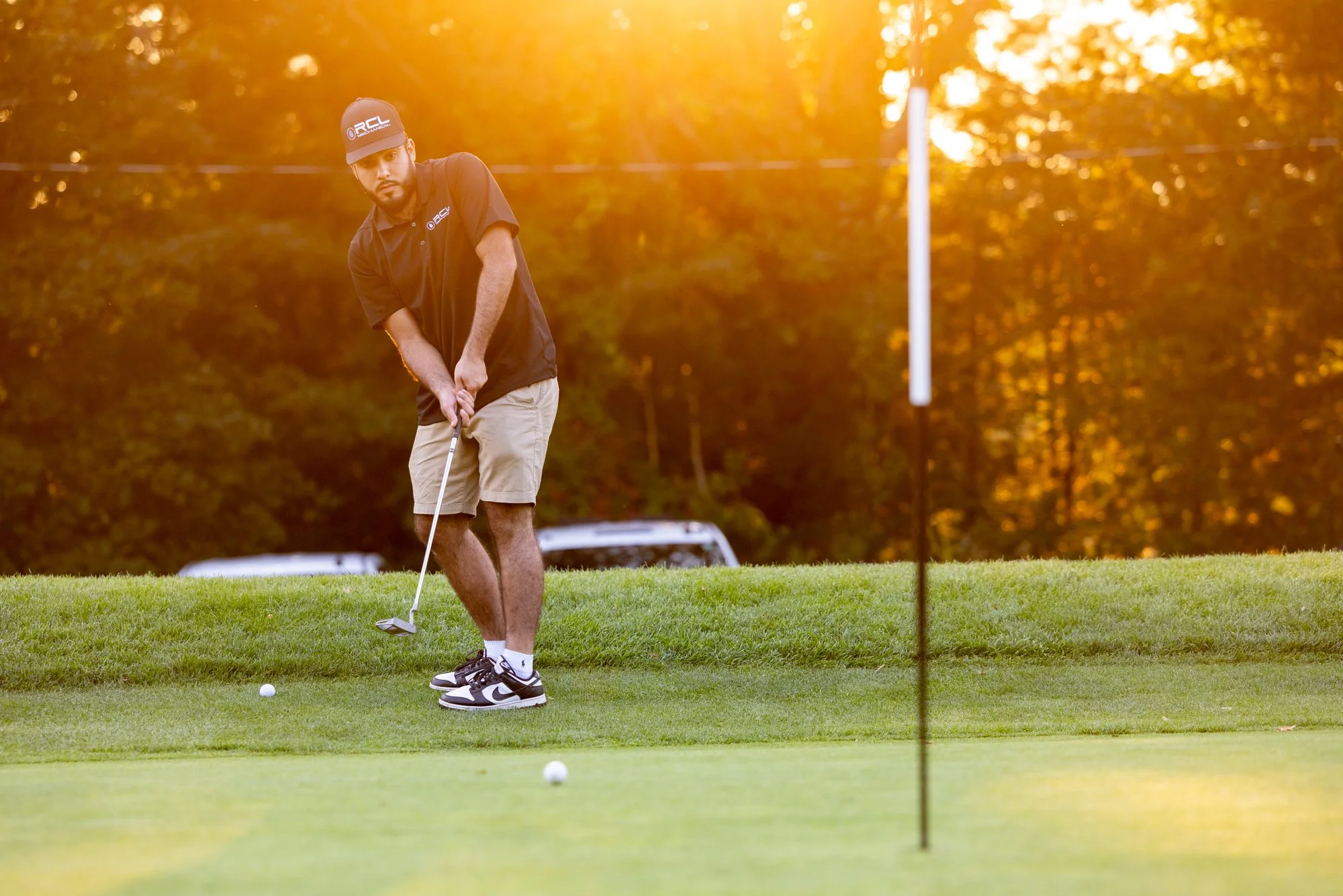 Golfer putting in warm light
