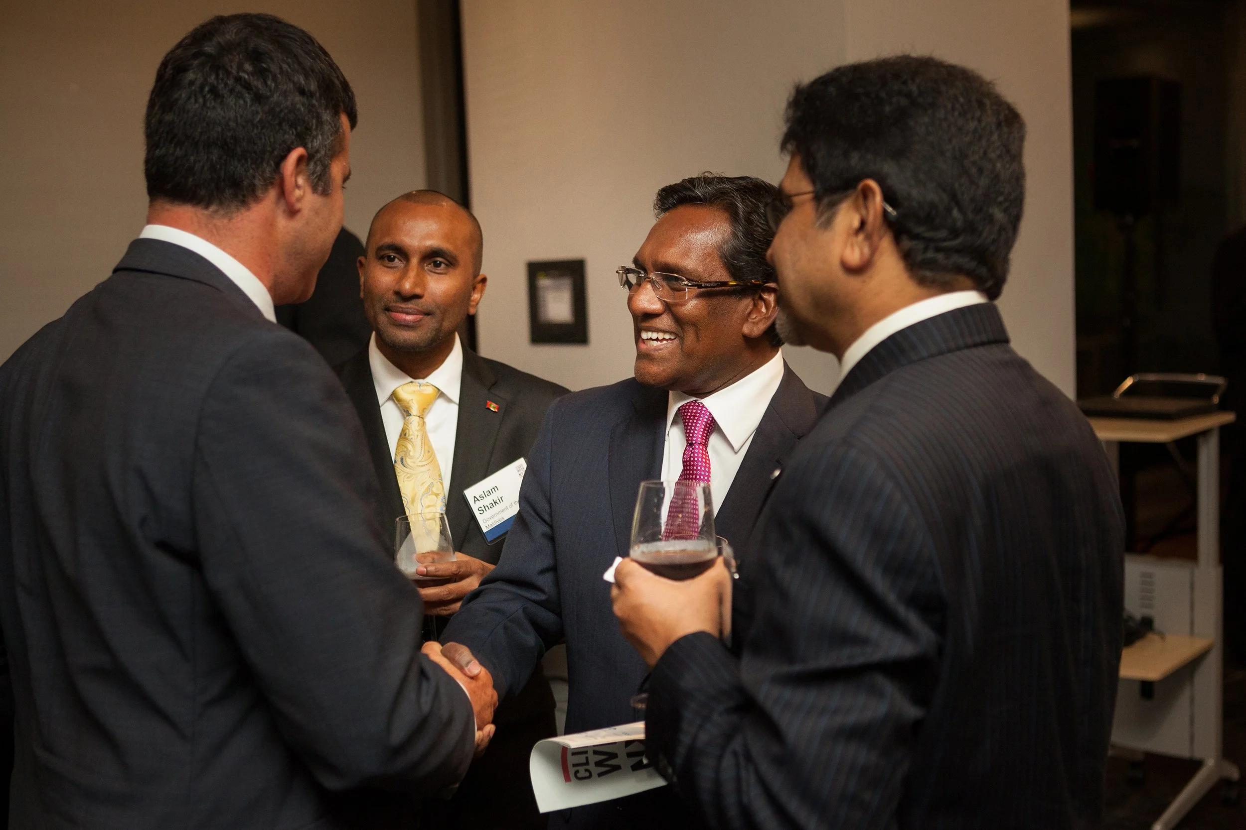 Man shaking hands surrounded by a group of other men