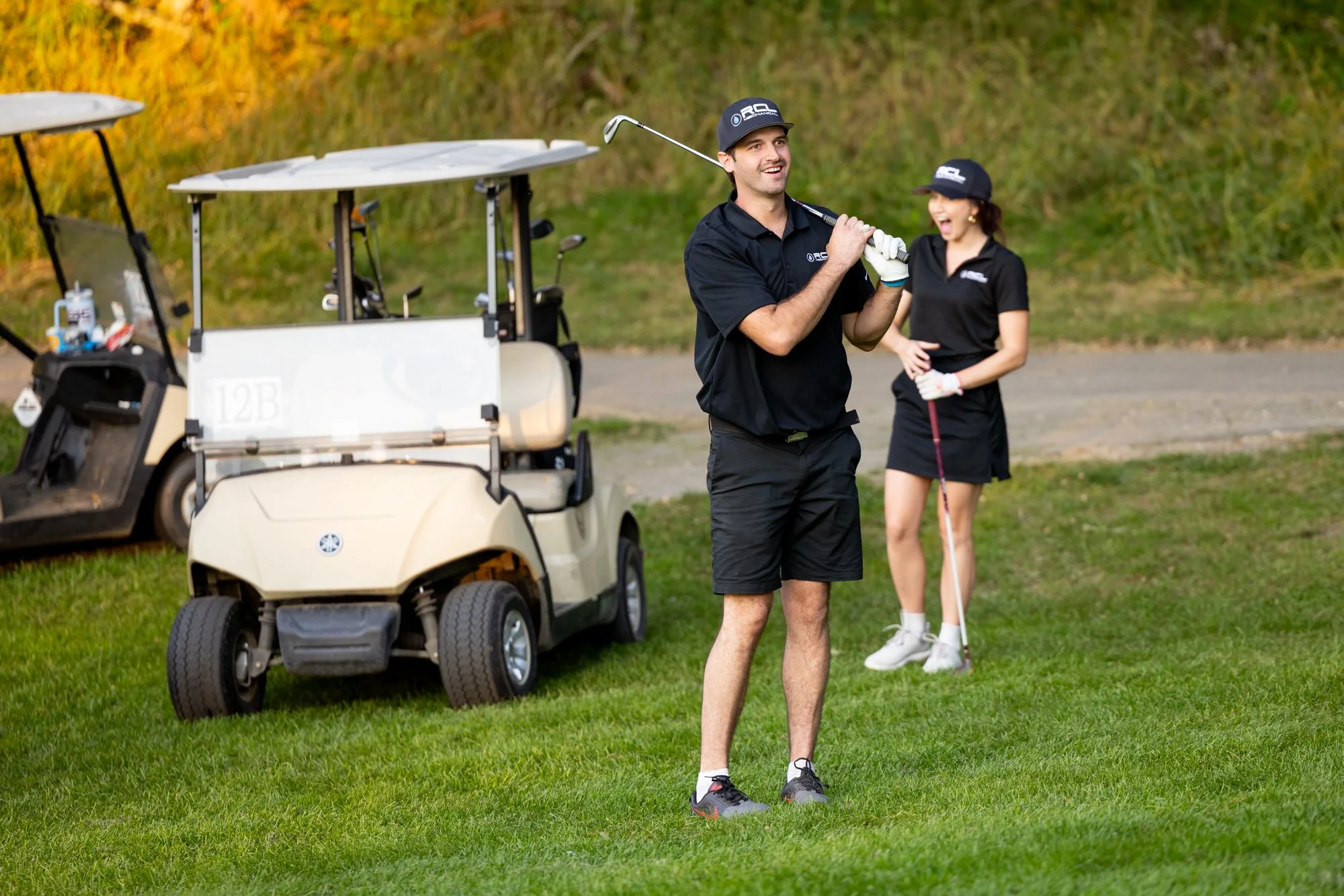 Man swinging golf club on fairway