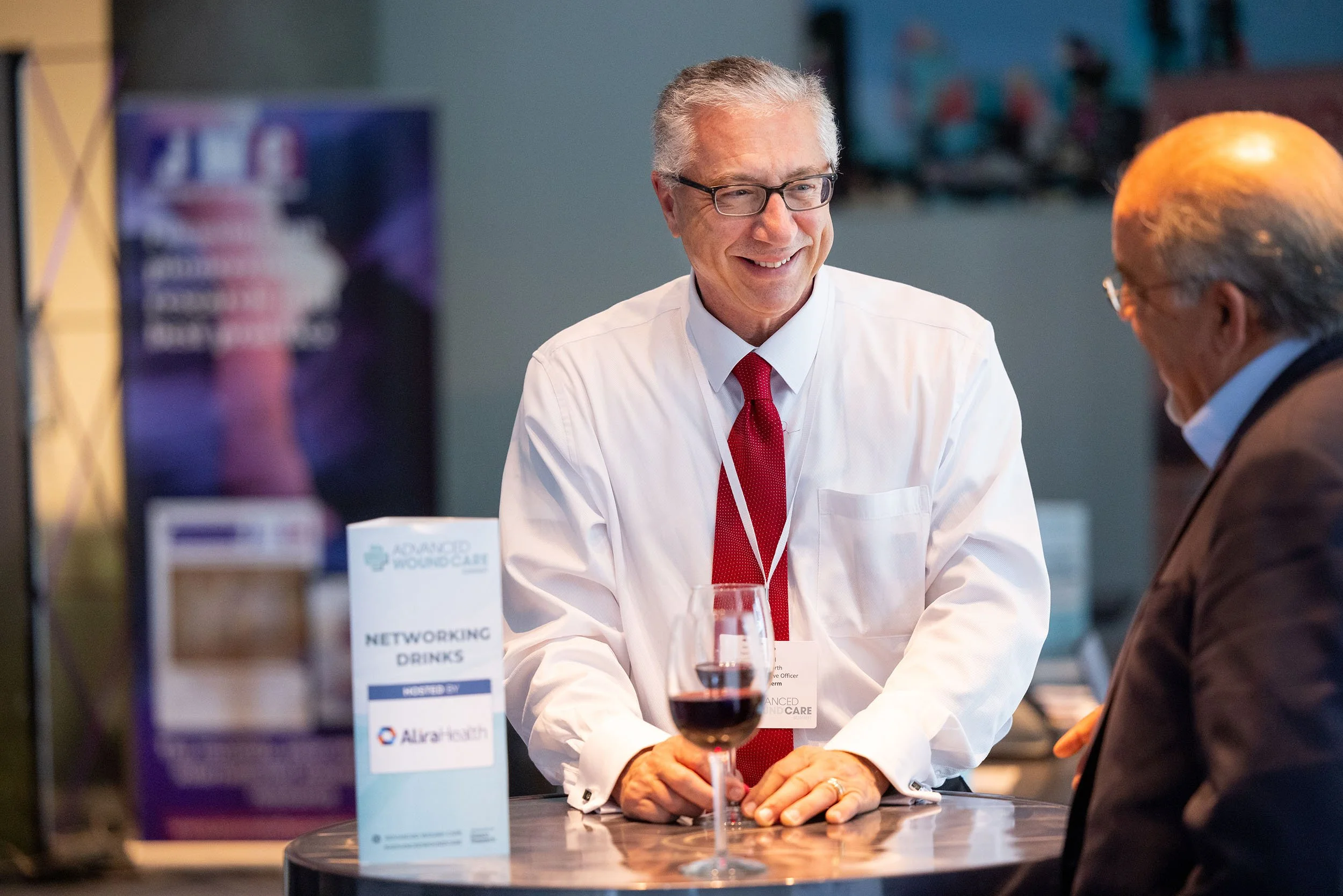 Two people standing at table networking during conference