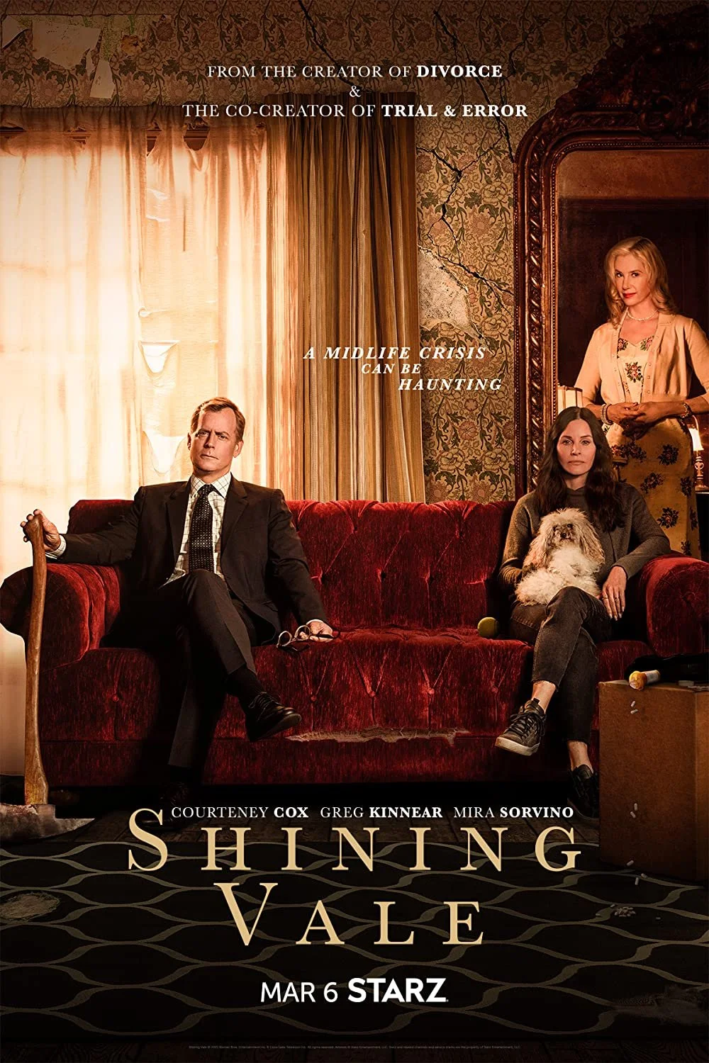 A promotional poster for the TV series "Shining Vale" showing three characters inside a room with vintage decor. One woman sits on a red velvet couch holding a dog, a man sits on the same couch holding glasses, and another woman stands behind them. T