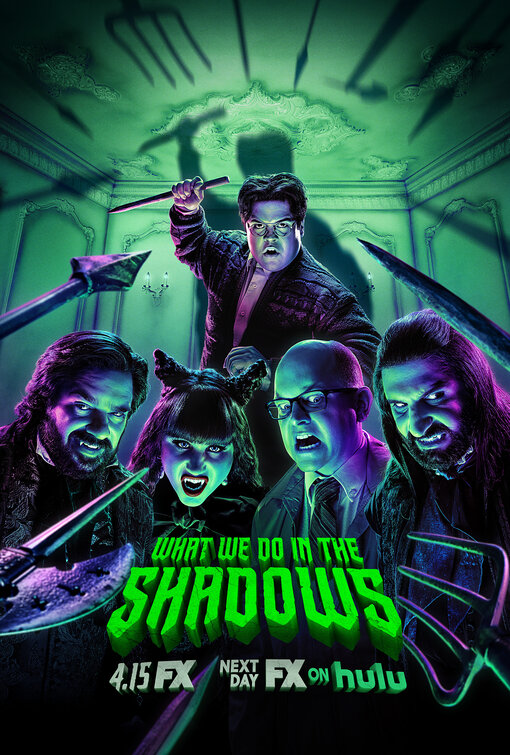 A promotional poster for the TV show "What We Do in the Shadows" features five characters with animated expressions in a dimly lit, ornate room illuminated with green and purple lighting. The central figure, standing at the back, holds a large knife.