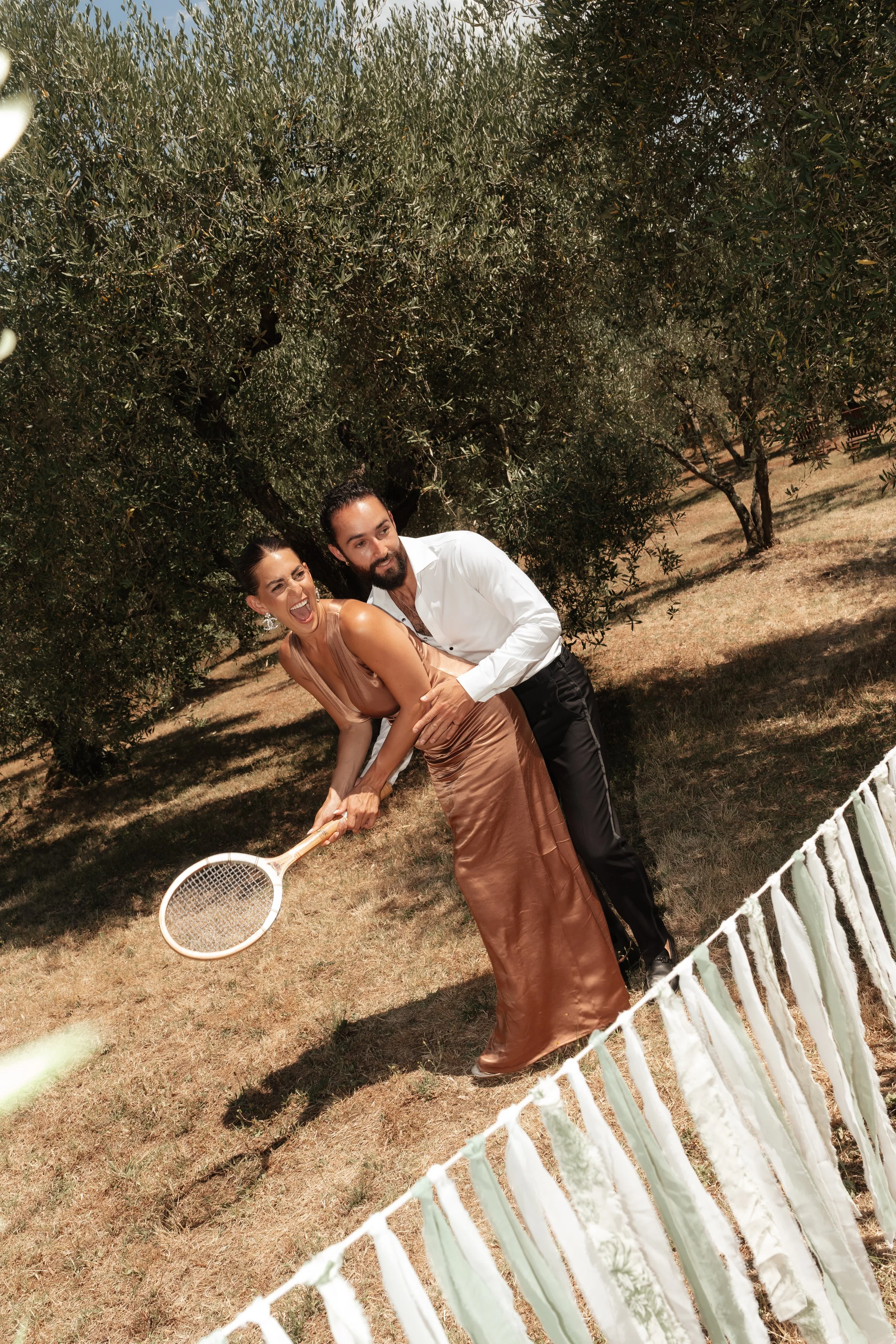 Couple playing tennis outdoors at wedding celebration at Villa Cozzano