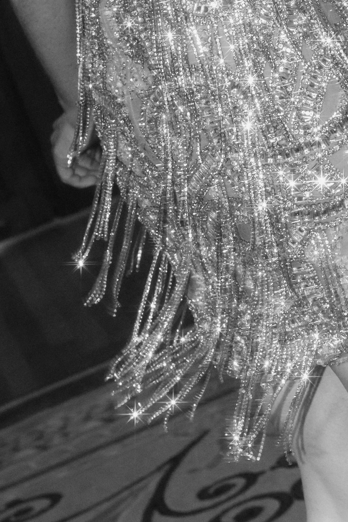 A close-up of numerous sparkling, rhinestone-encrusted jewelry and accessories, including chains, pendants, and decorative pieces.