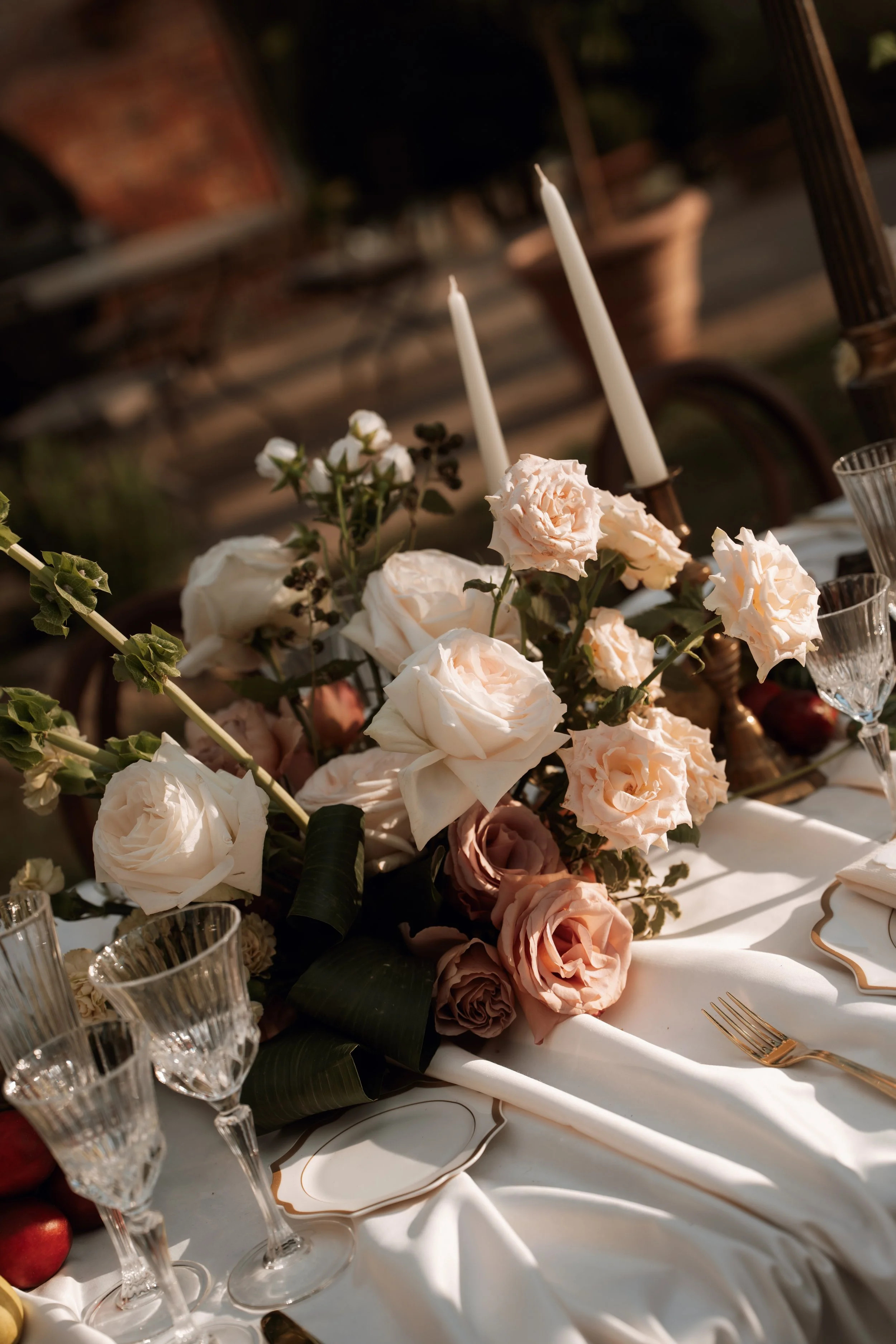 Outdoor wedding table with white and blush flowers and candles at Villa cozzano