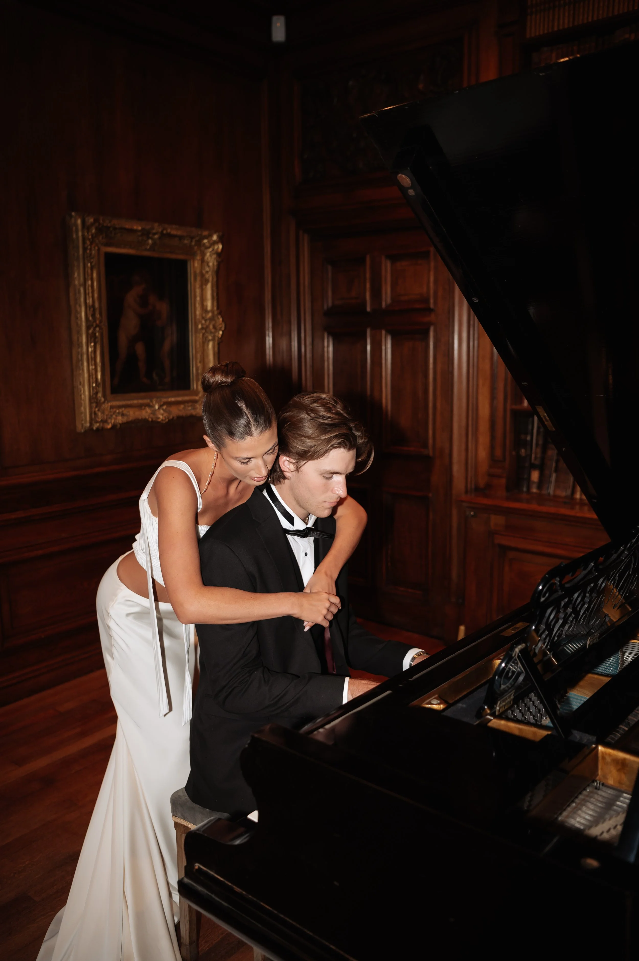 romantic wedding moment as Groom plays piano at Sudeley Castle 