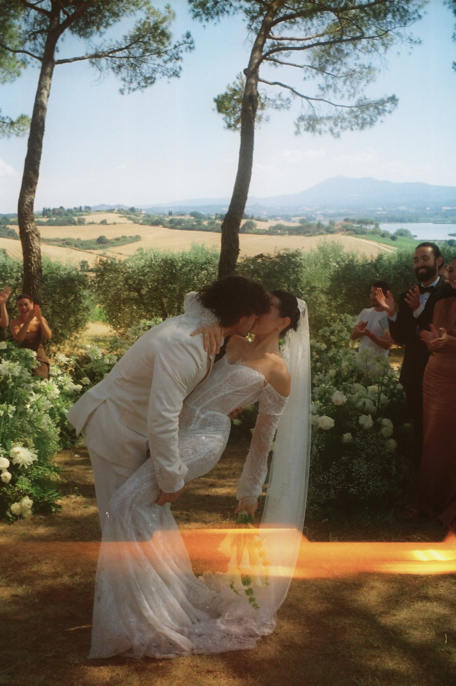 A bride and groom kissing during an outdoor wedding ceremony at Villa Cozzano Taken on 35mm film 