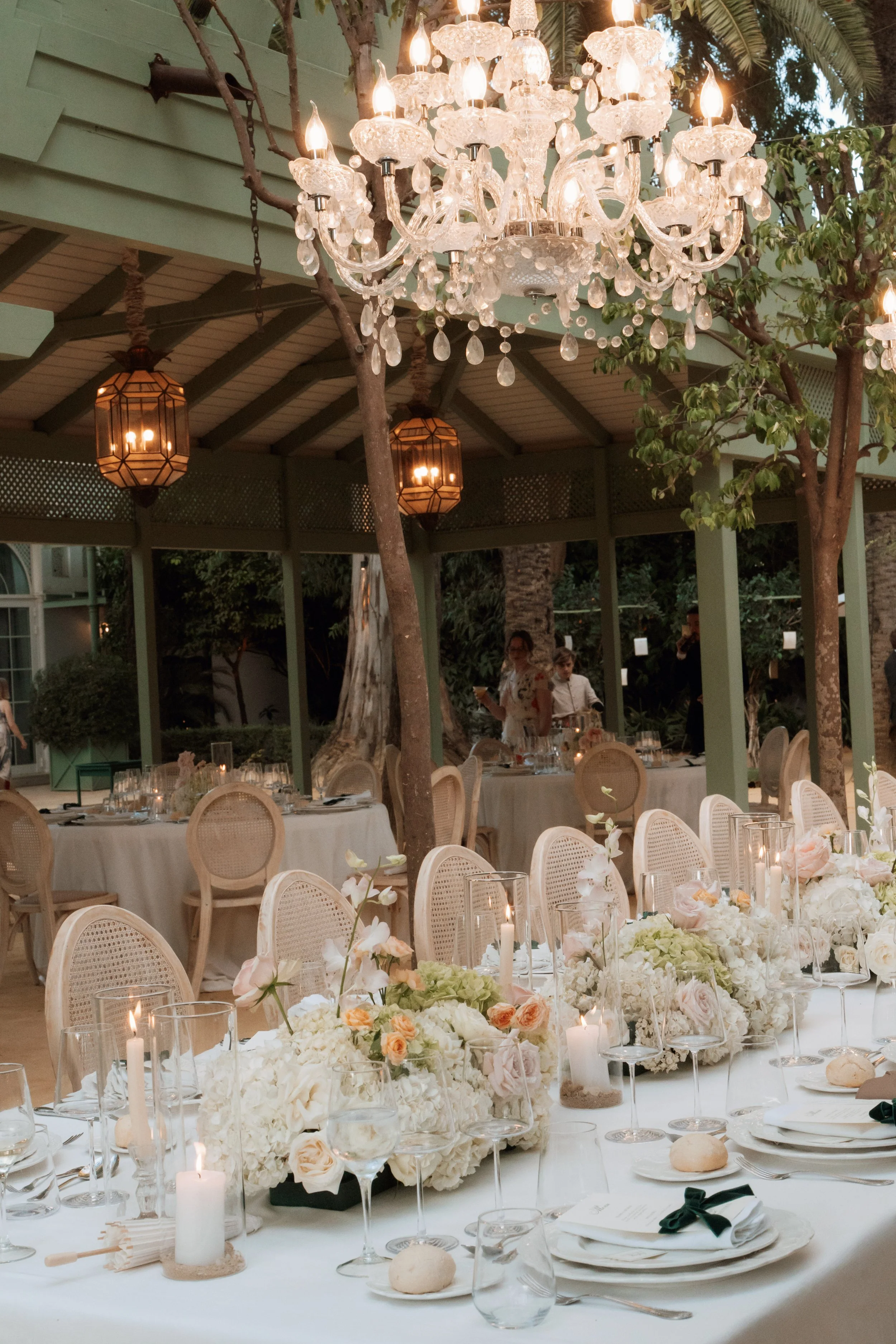 Outdoor long table decorated with flowers, candles, and greenery at Seville wedding 