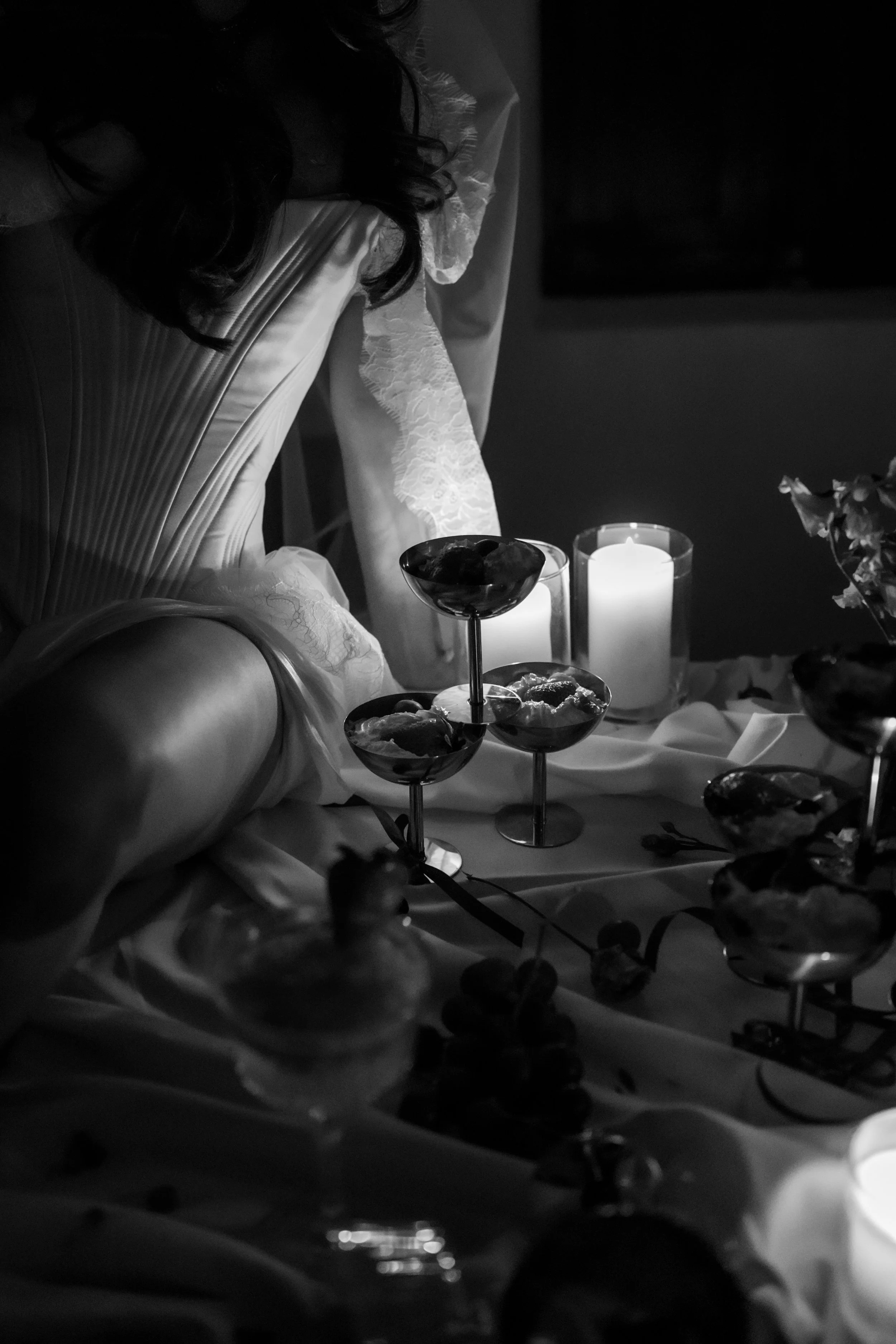 Woman in satin dress sitting at table with candles and wine  Finca Paissa d'en Bernat in Ibiza 