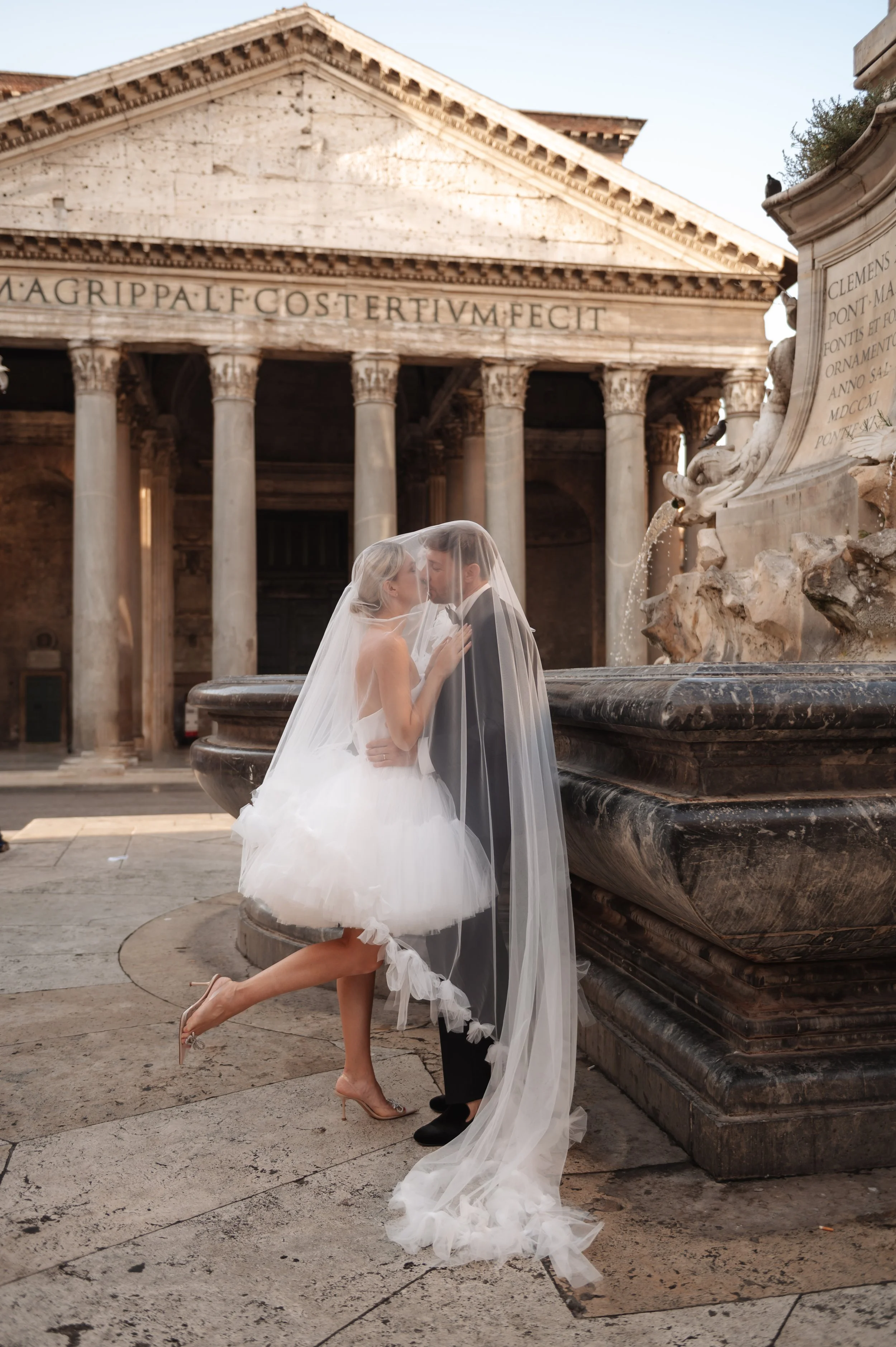 Bride and groom standing in front of Pantheon in Rome with fountain