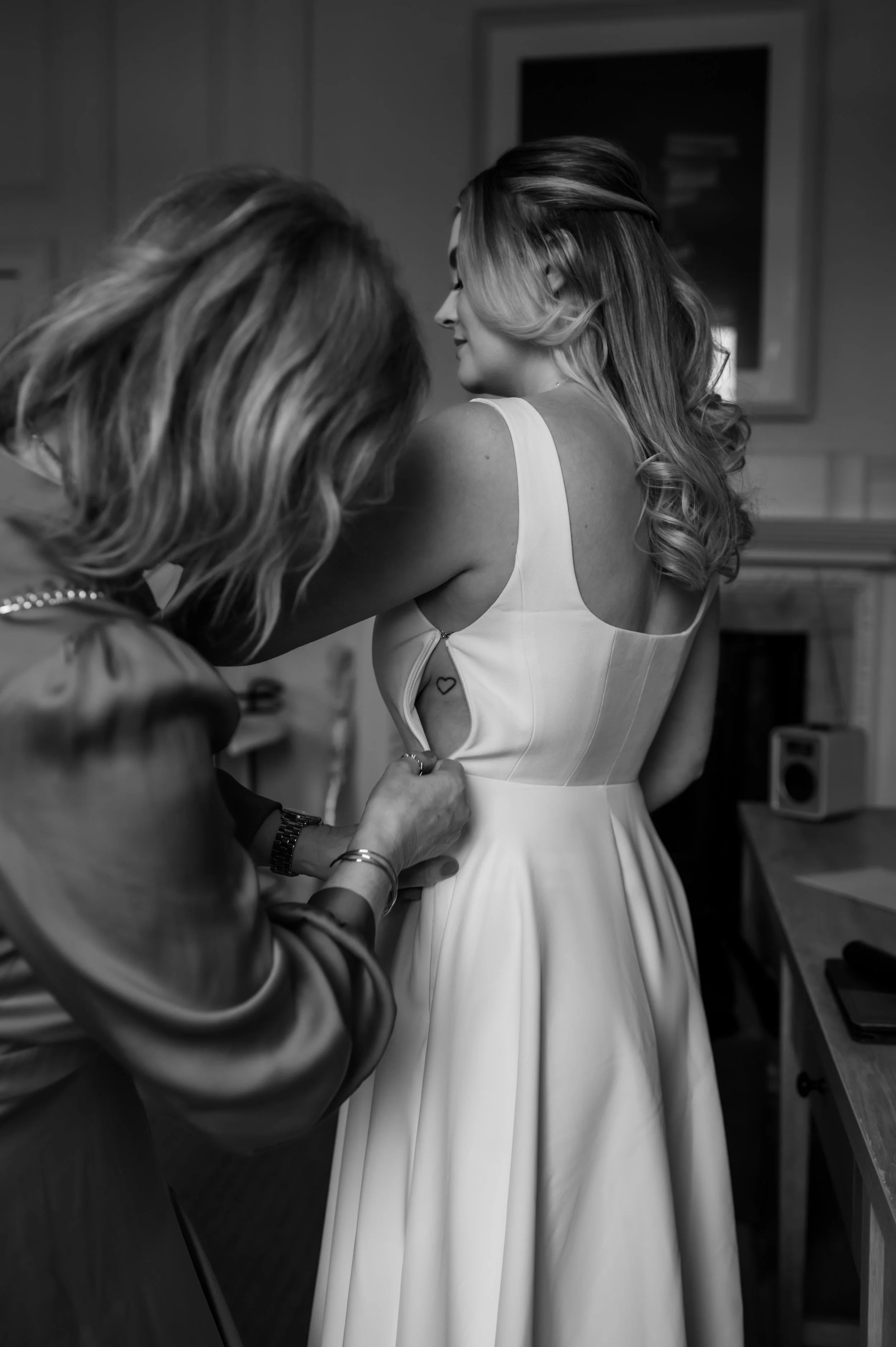 Bride assisted with dress zipper by Mother on wedding morning in York 