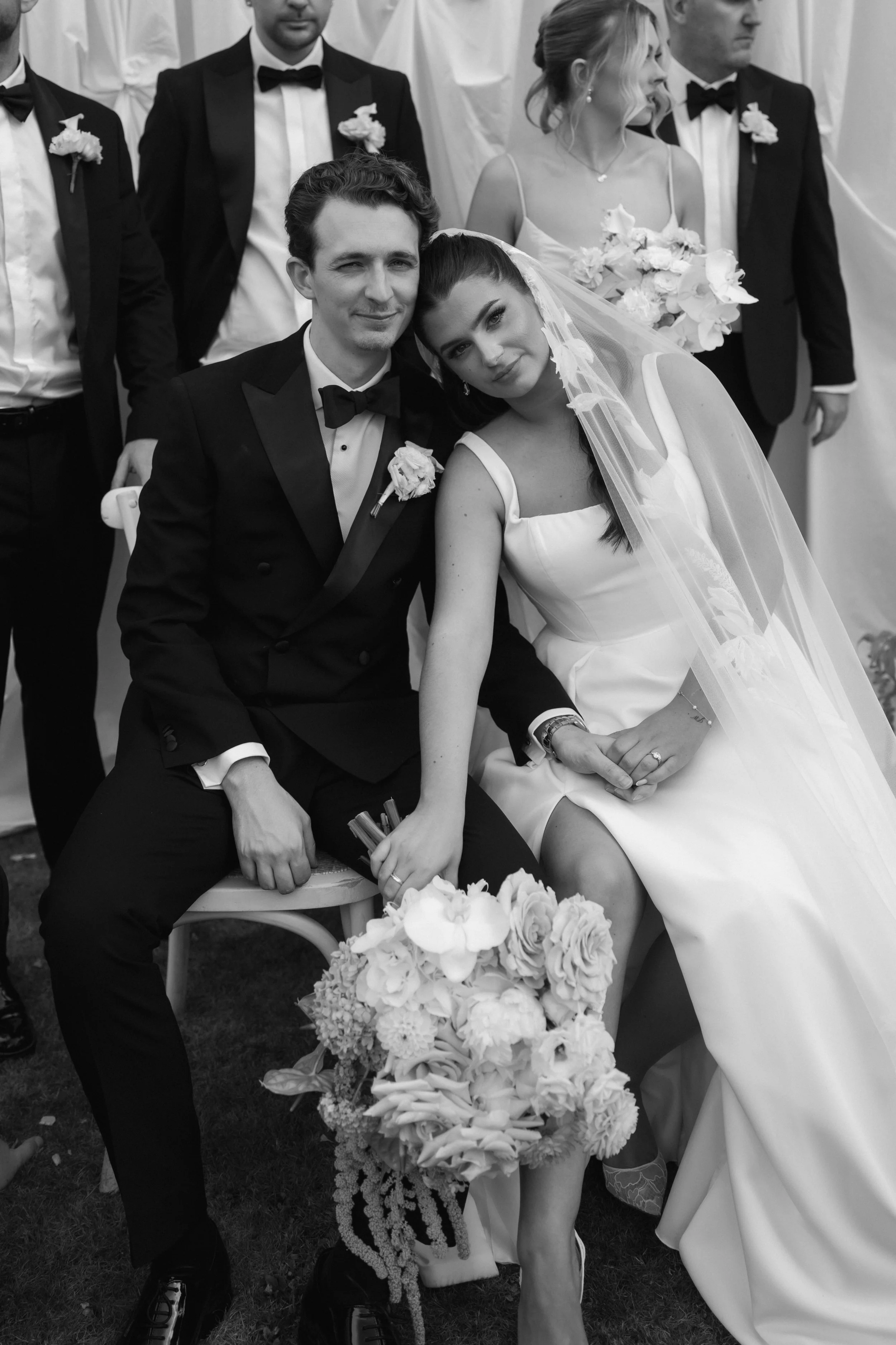 Bride and groom seated with wedding party during editorial wedding