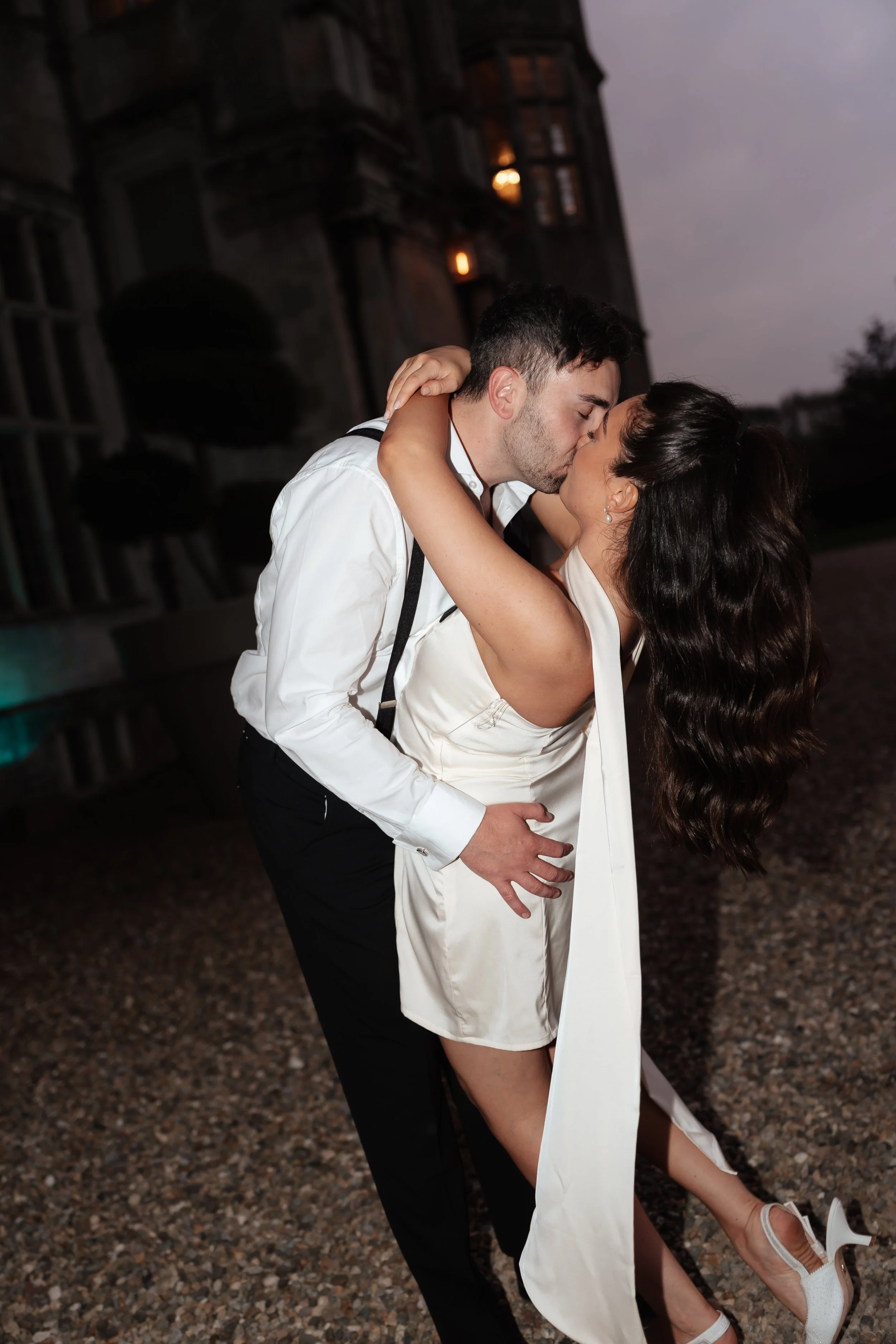 Couple sharing a kiss outdoors during evening wedding at Howsham hall 