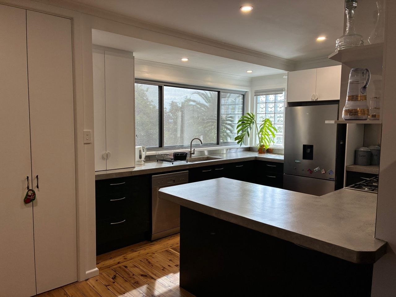 Modern kitchen renovation featuring concrete benchtops, timber flooring, stainless steel splashback and custom cabinetry completed by Westside Interior Exterior in Albury.