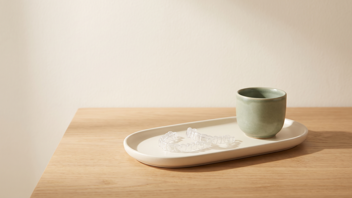 Clear Invisalign aligners on a ceramic tray in a calm Berkeley dental office, Total Health Dental Care