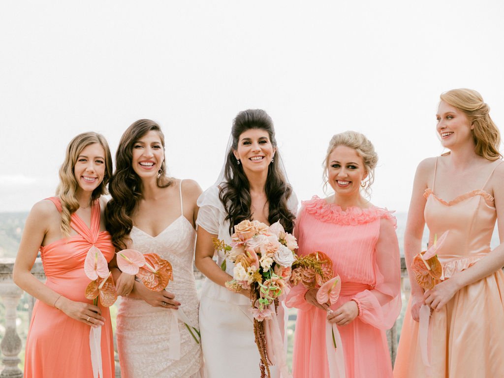 Bridesmaids dressed in neon pink and peach vintage dresses