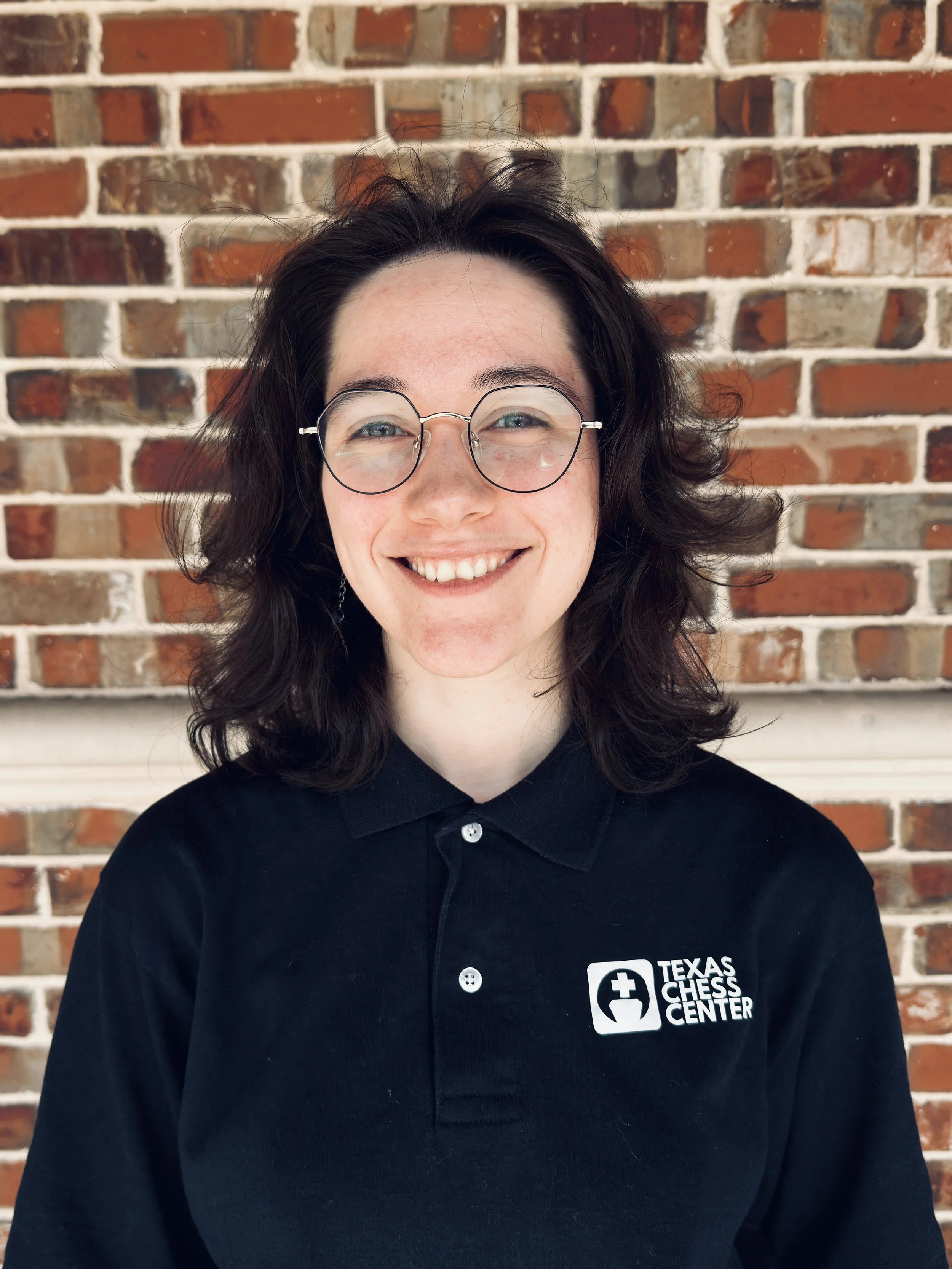 A close-up of a wooden chess piece, a pawn, placed on a chessboard against a dark background.