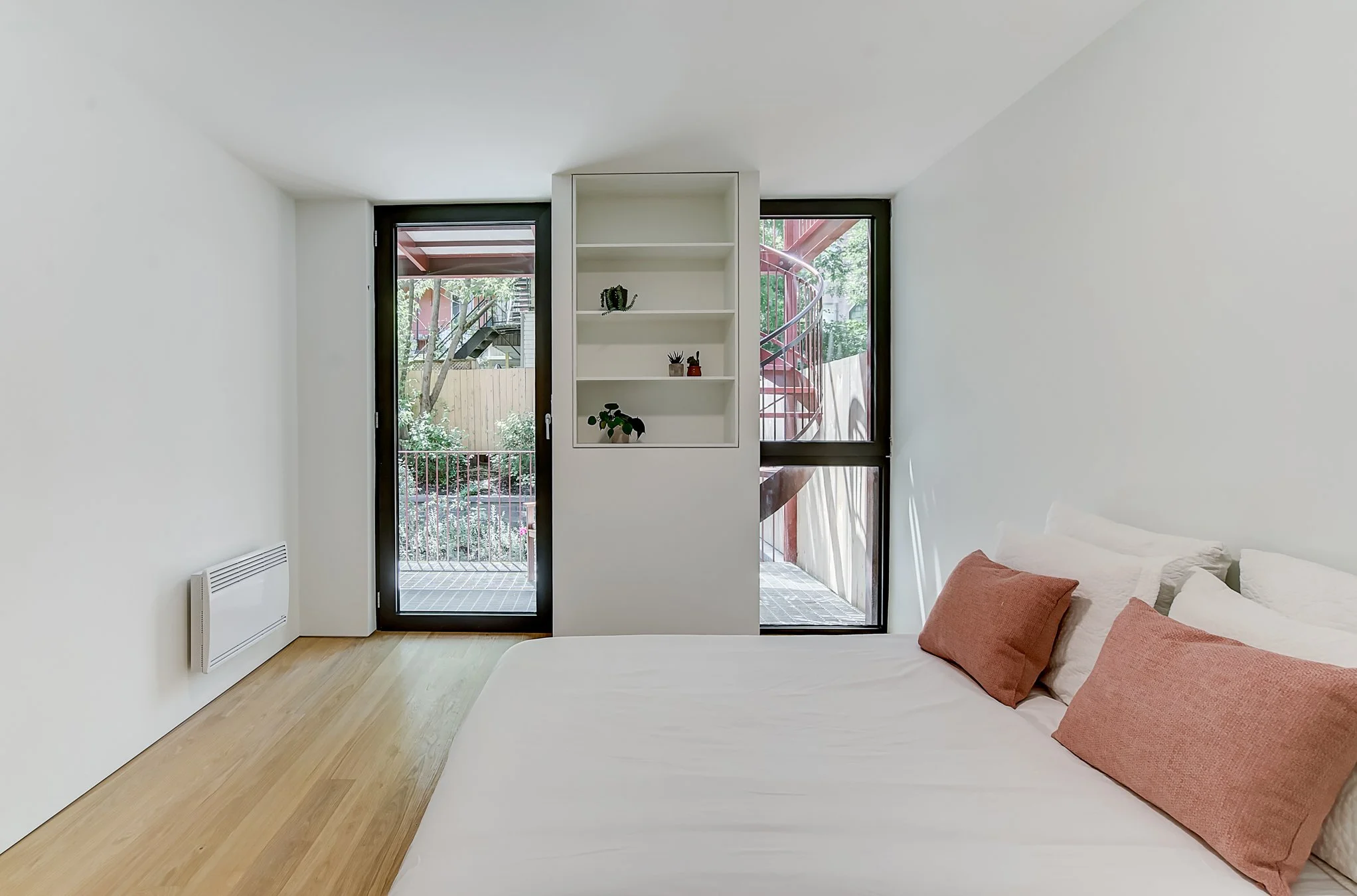 Minimalist bedroom, white oak flooring light wood floor giving out to balcony and english garden.