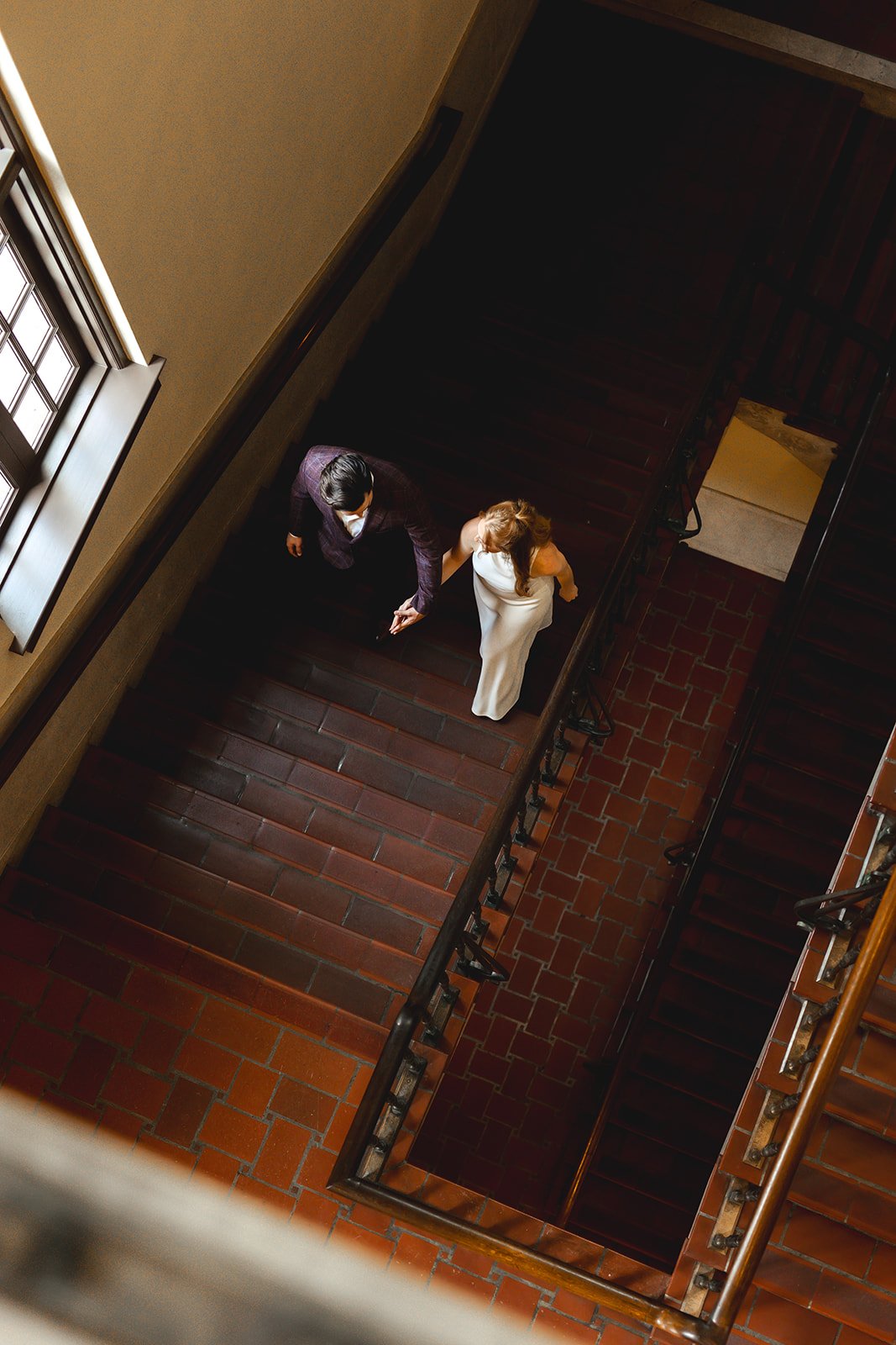 Couple walking during their engagement session at the Julia Ideson Building downtown in the Houston Historic Library by Houston Top Rated Engagement and Wedding Photographer Wild Ivy Creative
