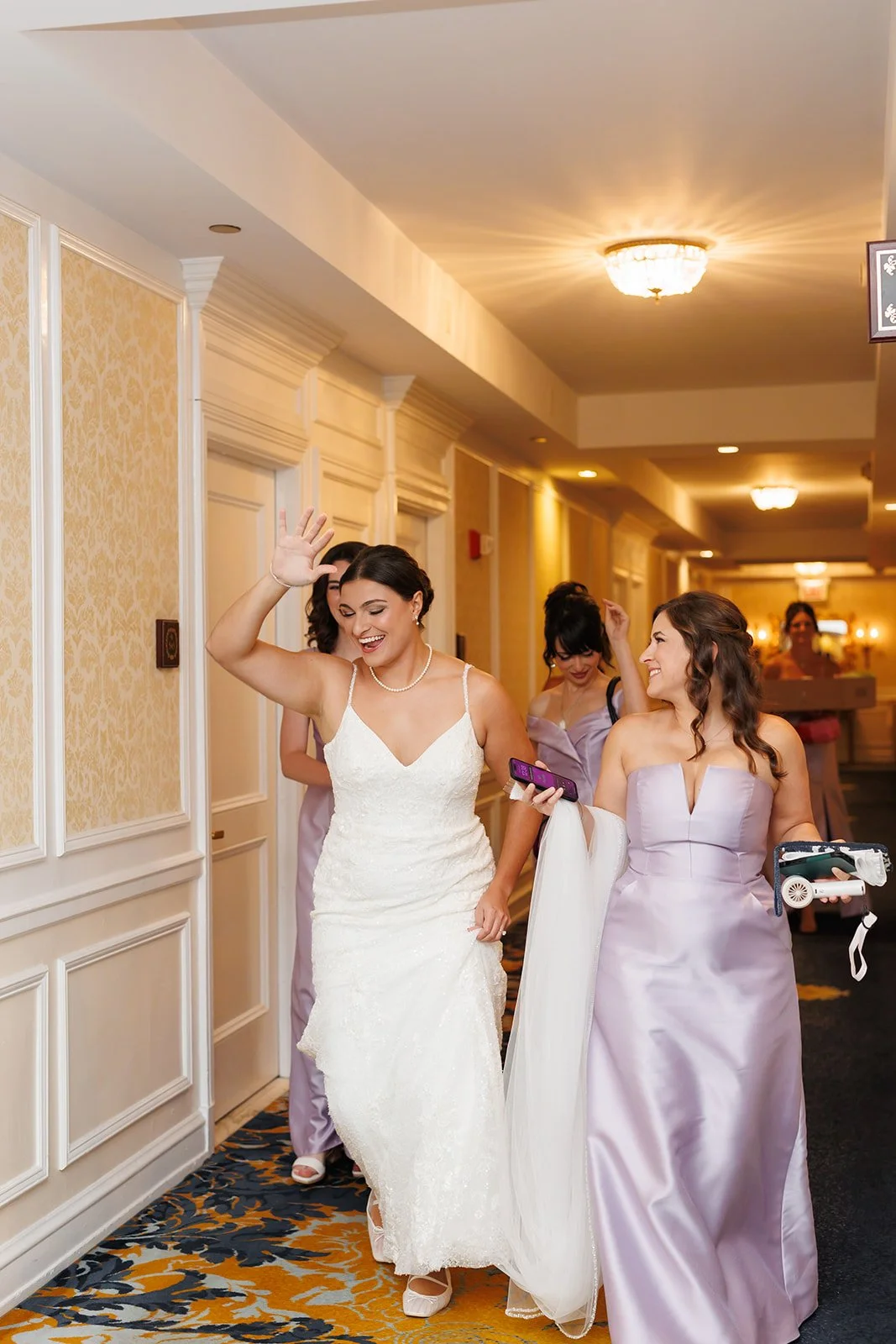 Bride and bridesmaids laughing and dancing together in hotel hallway – The Woodlands wedding photographer – Wild Ivy Creative Photography