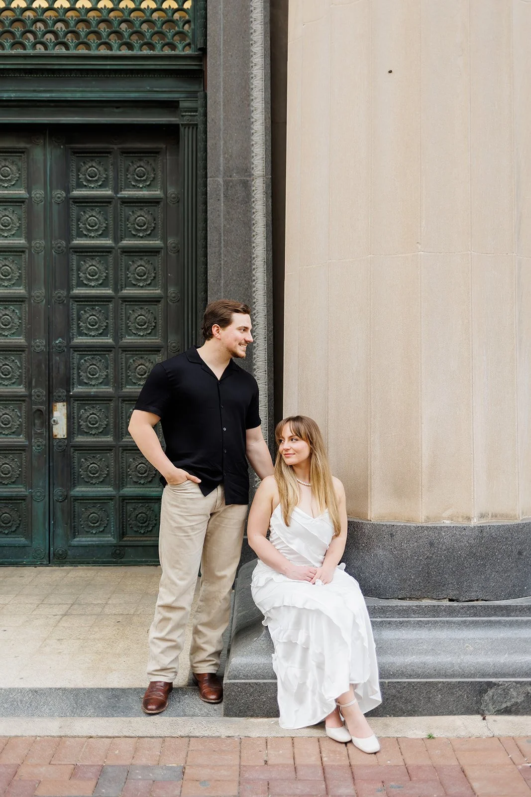 Houston engagement session with a couple chatting beside grand columns and a green door — styled and captured by Wild Ivy Creative.