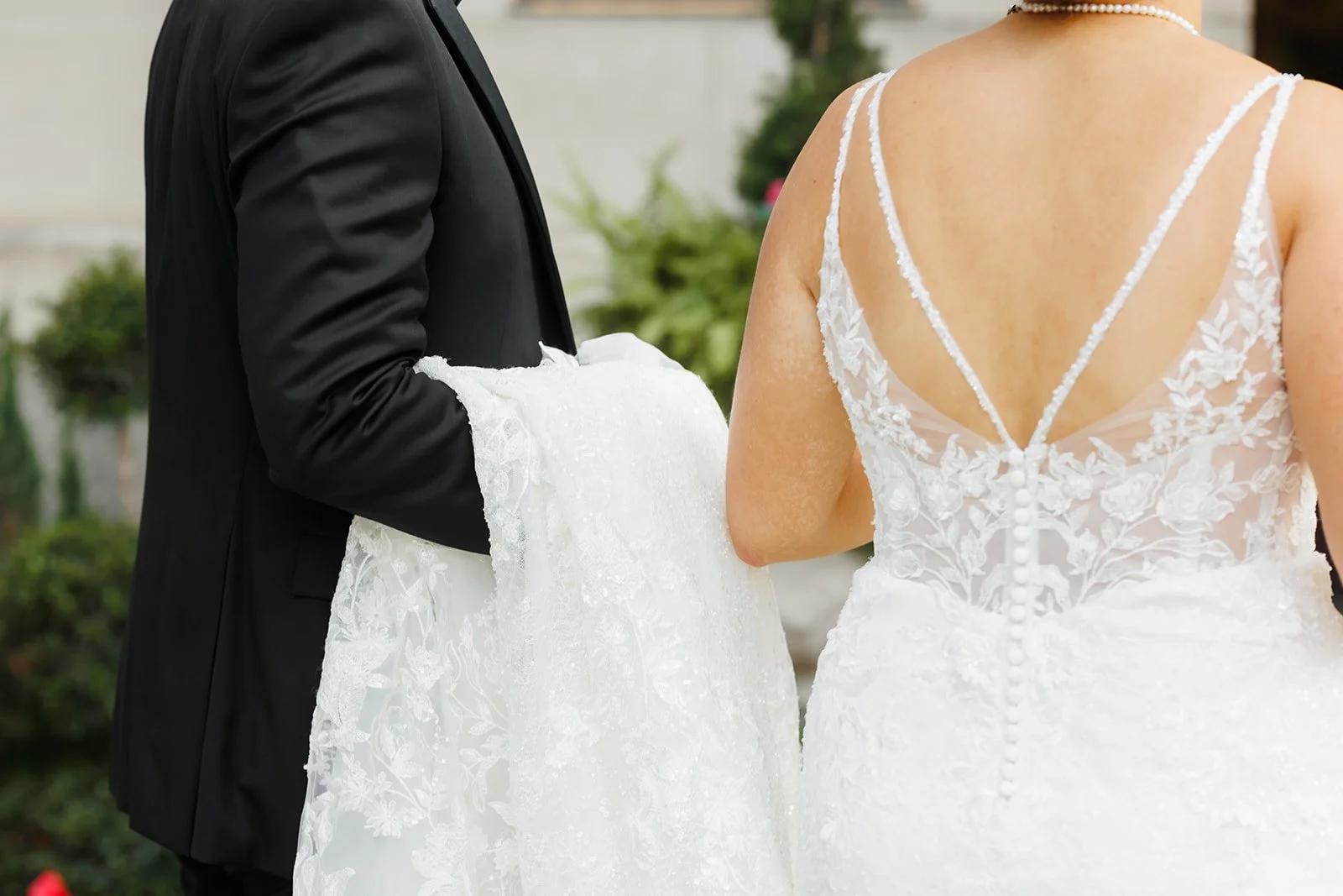 Groom holding brides dress, detail wedding shots captured by Houston Wedding and Engagement Photographer Wild Ivy Creative Houston