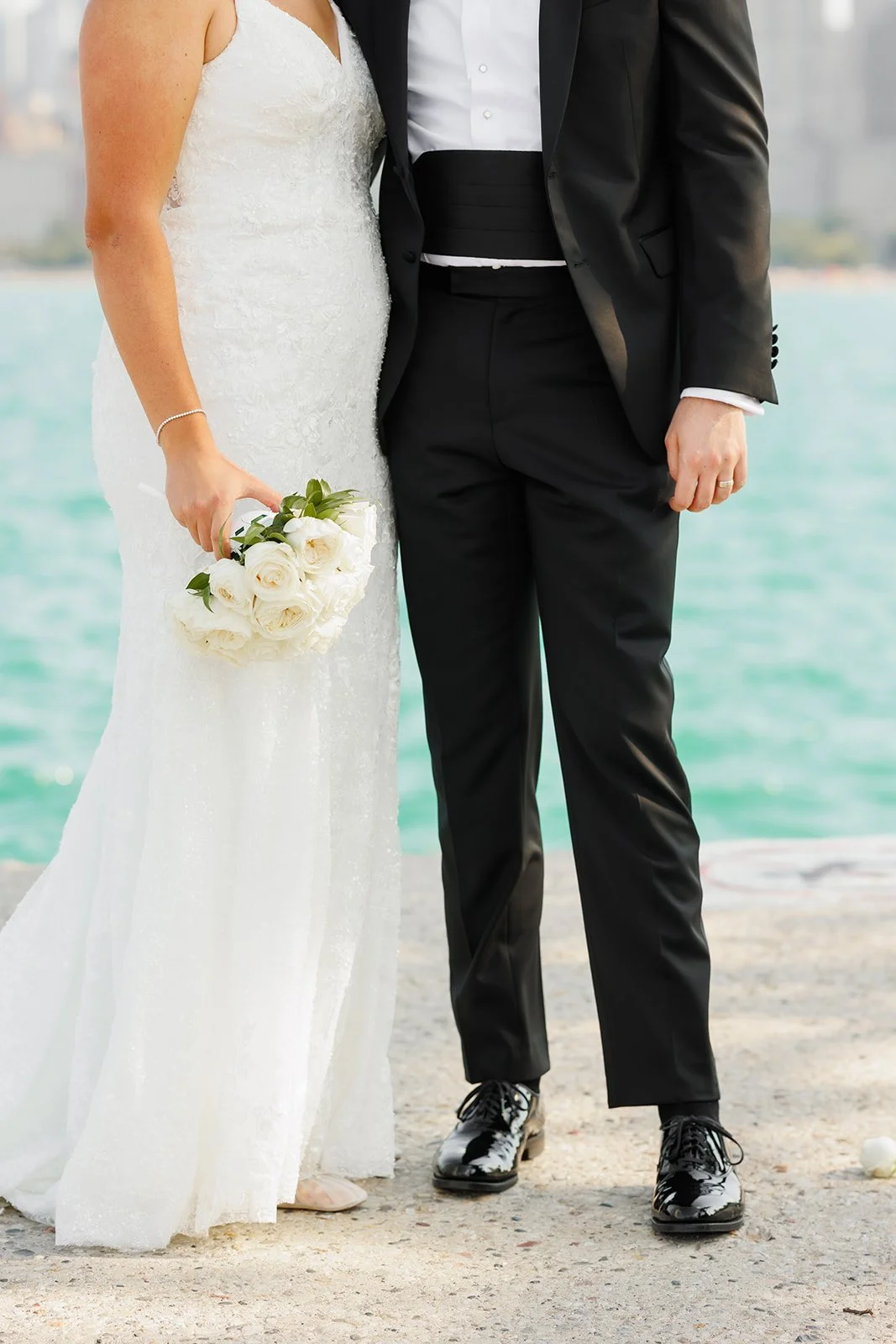 Close-up of bride’s lace gown and bouquet with skyscrapers behind – Houston wedding photography – Wild Ivy Creative Photography