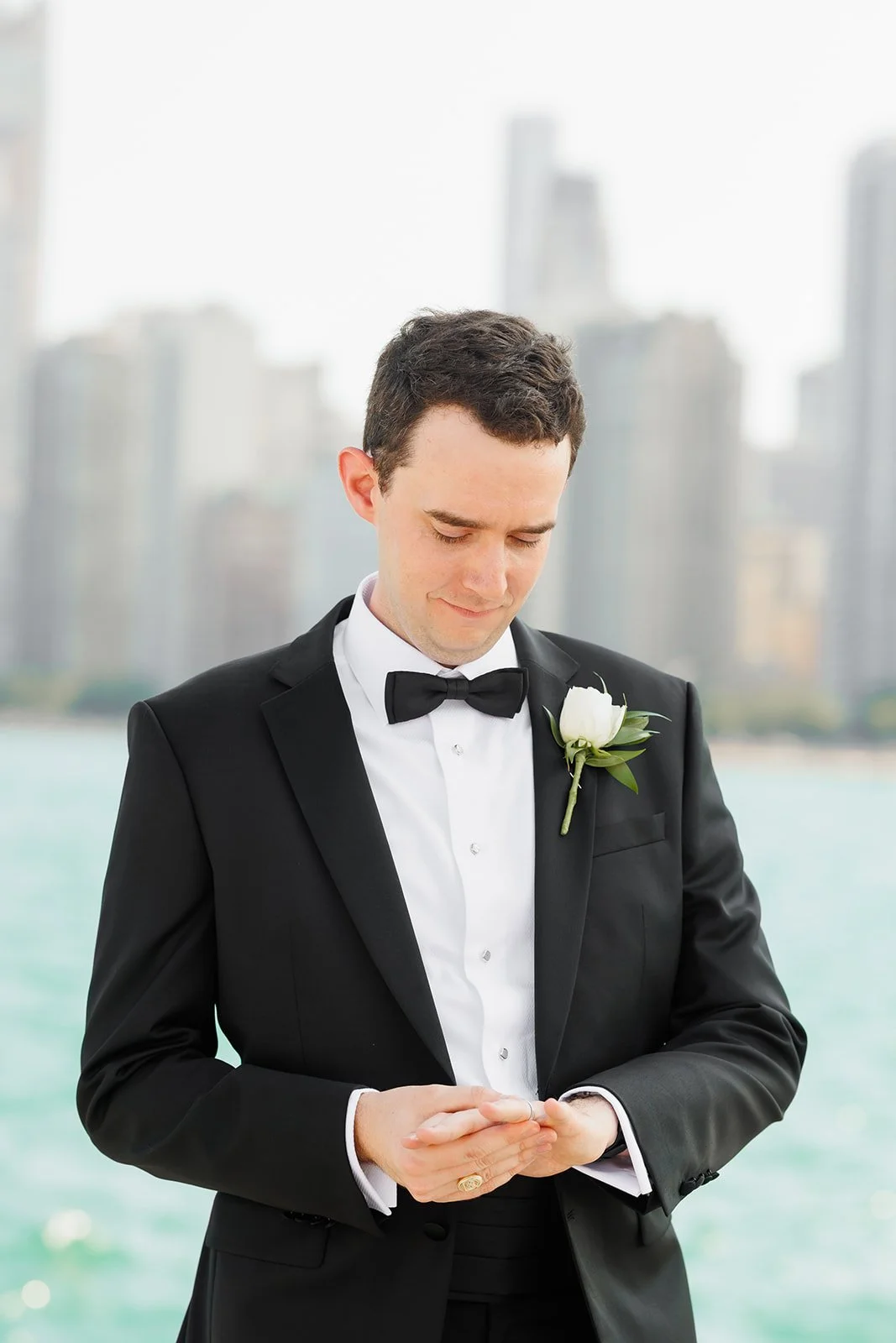 Groom looking at wedding ring in front of city skyline after wedding ceremony in Houston by Woodlands photographer Wild Ivy Creative