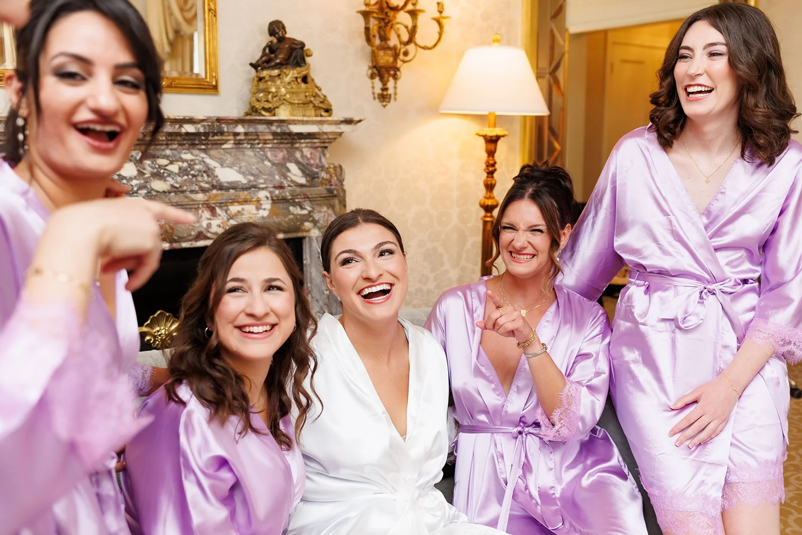 Bride and bridesmaids laughing together in elegant hotel suite in luxury hotel – Houston wedding photographer – Wild Ivy Creative Photography