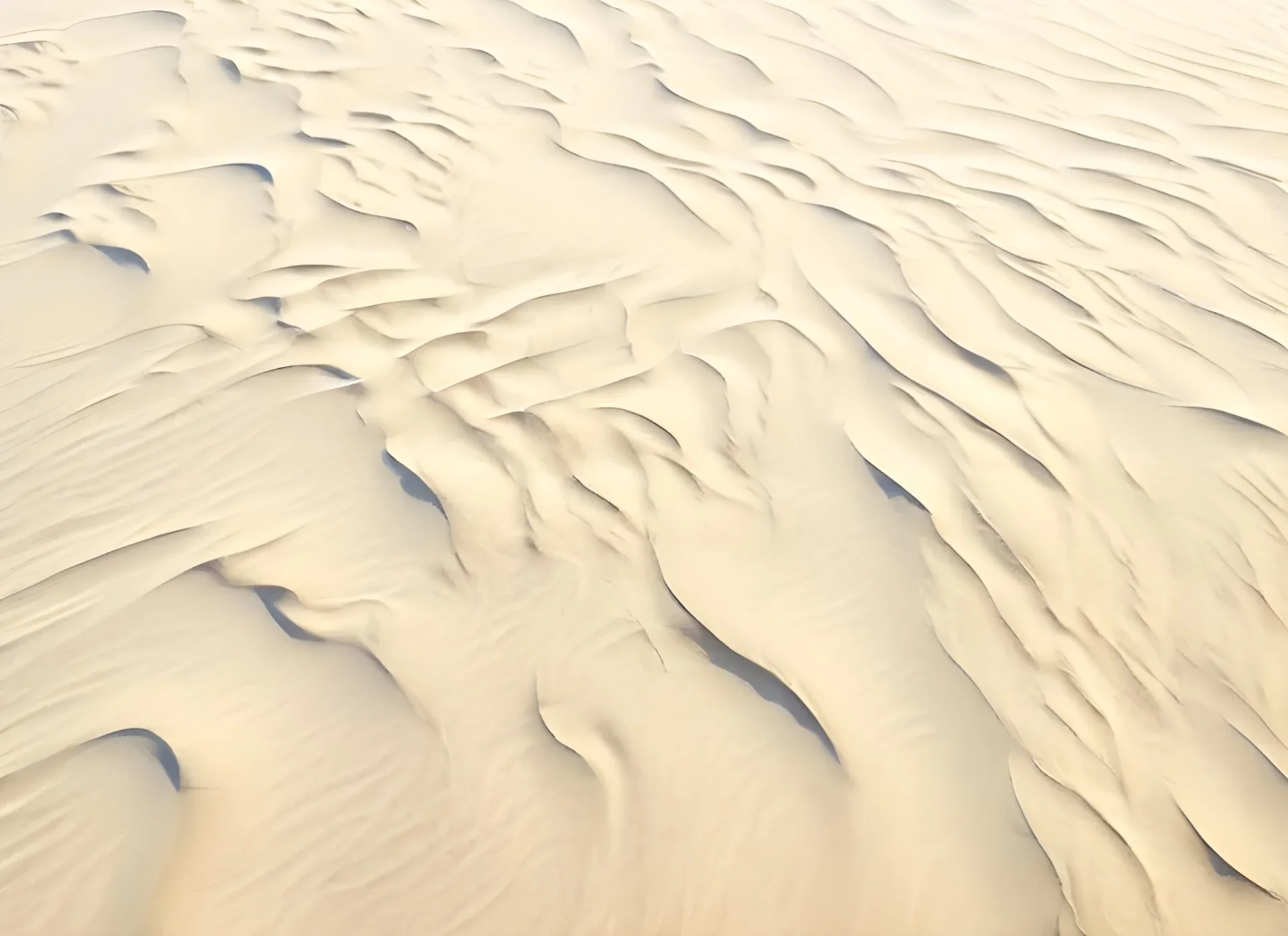 Vista aérea de dunas de arena moldeadas por el viento con ondulaciones suaves
