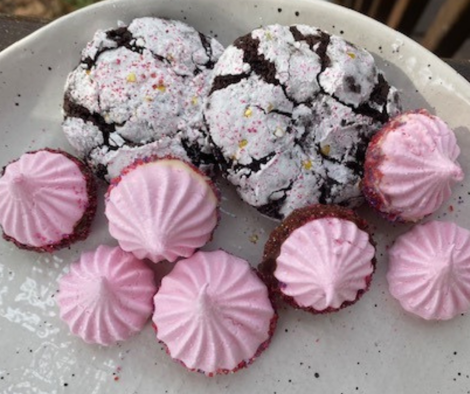 chocolate crinkle cookies, pink meringues dipped in chocolate and red sprinkles